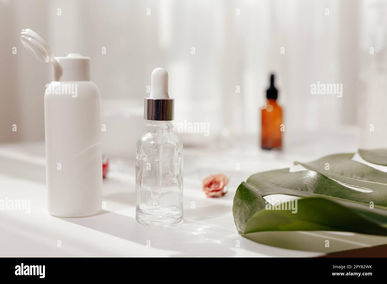 Vasetti di vetro con olio ed estratti su tavola bianca. Fare fragranza Foto Stock