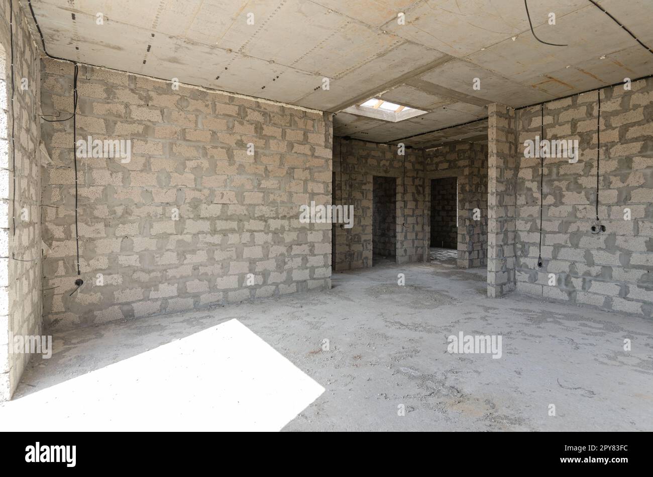 Costruzione di un edificio residenziale individuale, una grande camera spaziosa con un pavimento in cemento e soffitti in cemento armato Foto Stock