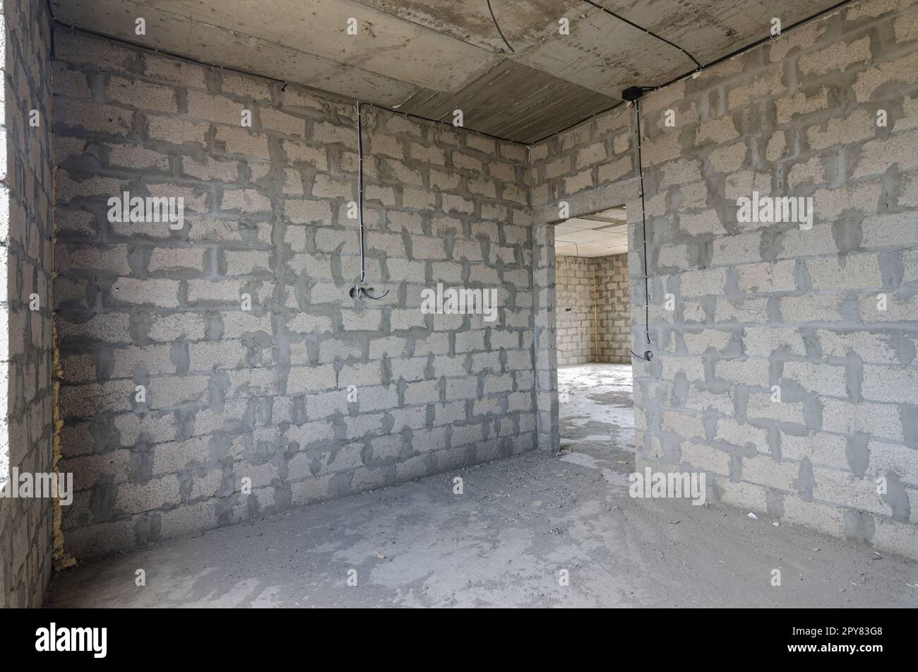 Costruzione di un edificio residenziale individuale, vista dell'angolo della stanza, una delle pareti con una porta Foto Stock