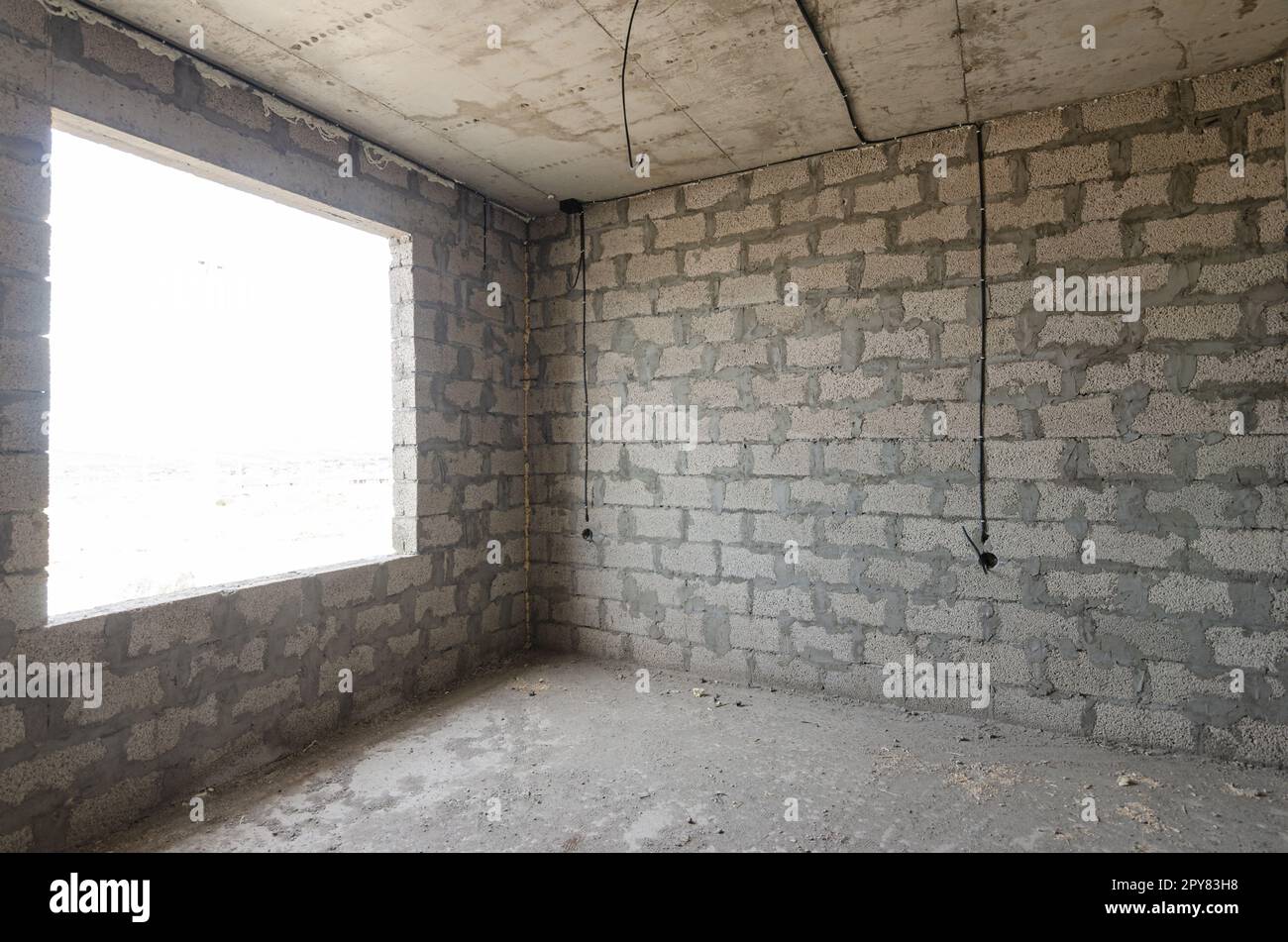 La costruzione di un edificio residenziale individuale, una vista della parete di cemento argilloso espanso senza finiture e una grande finestra spaziosa Foto Stock