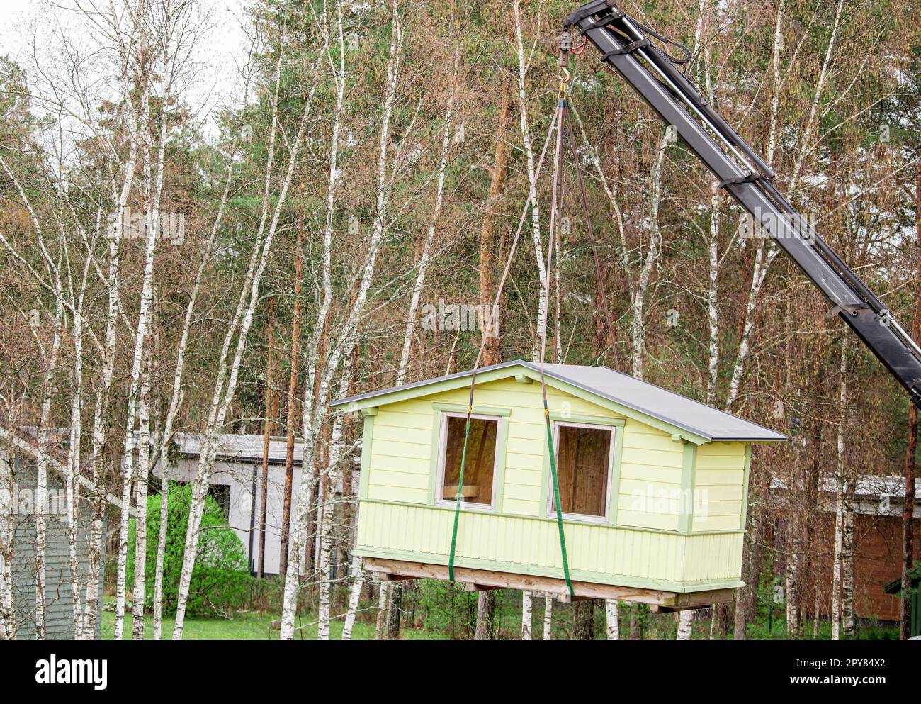 Gru sollevare la piccola casa all'aperto in primavera in natura. Foto Stock