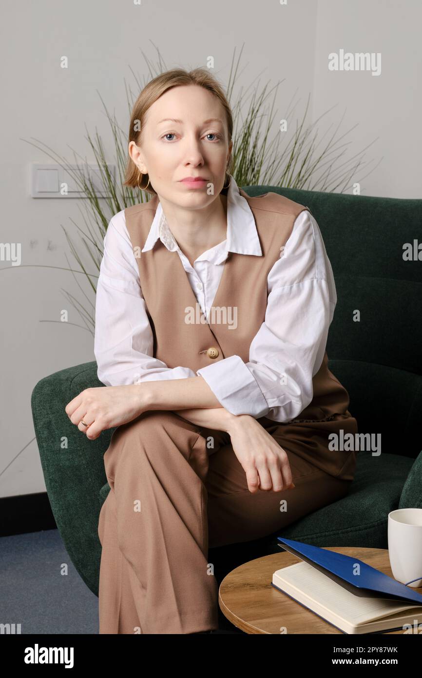 Donna sicura e positiva seduta in un ambiente chiuso Foto Stock