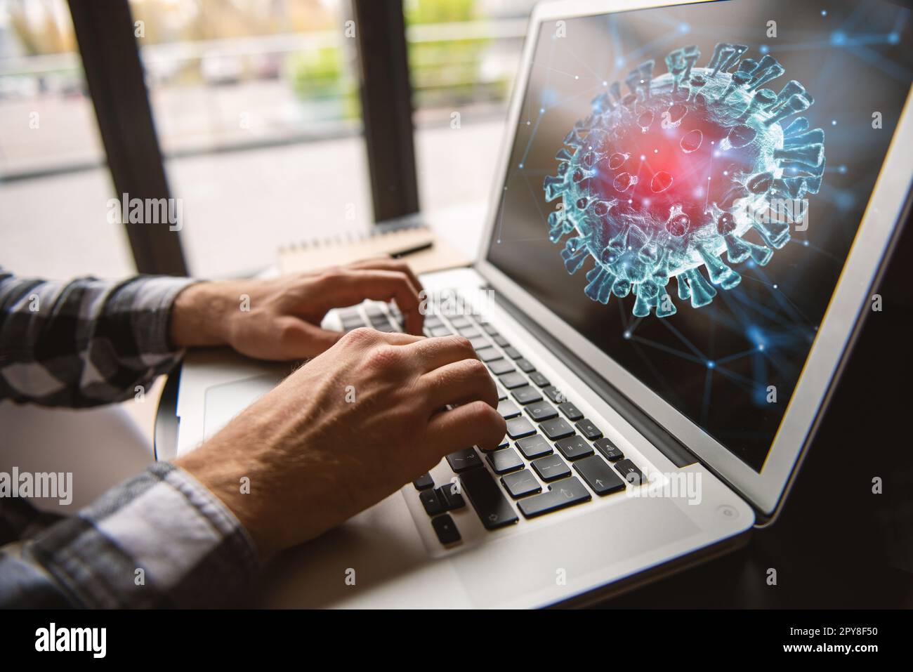 Businessman lavora in ufficio con un laptop e cerca notizie su coronavirus covid-19. Foto Stock