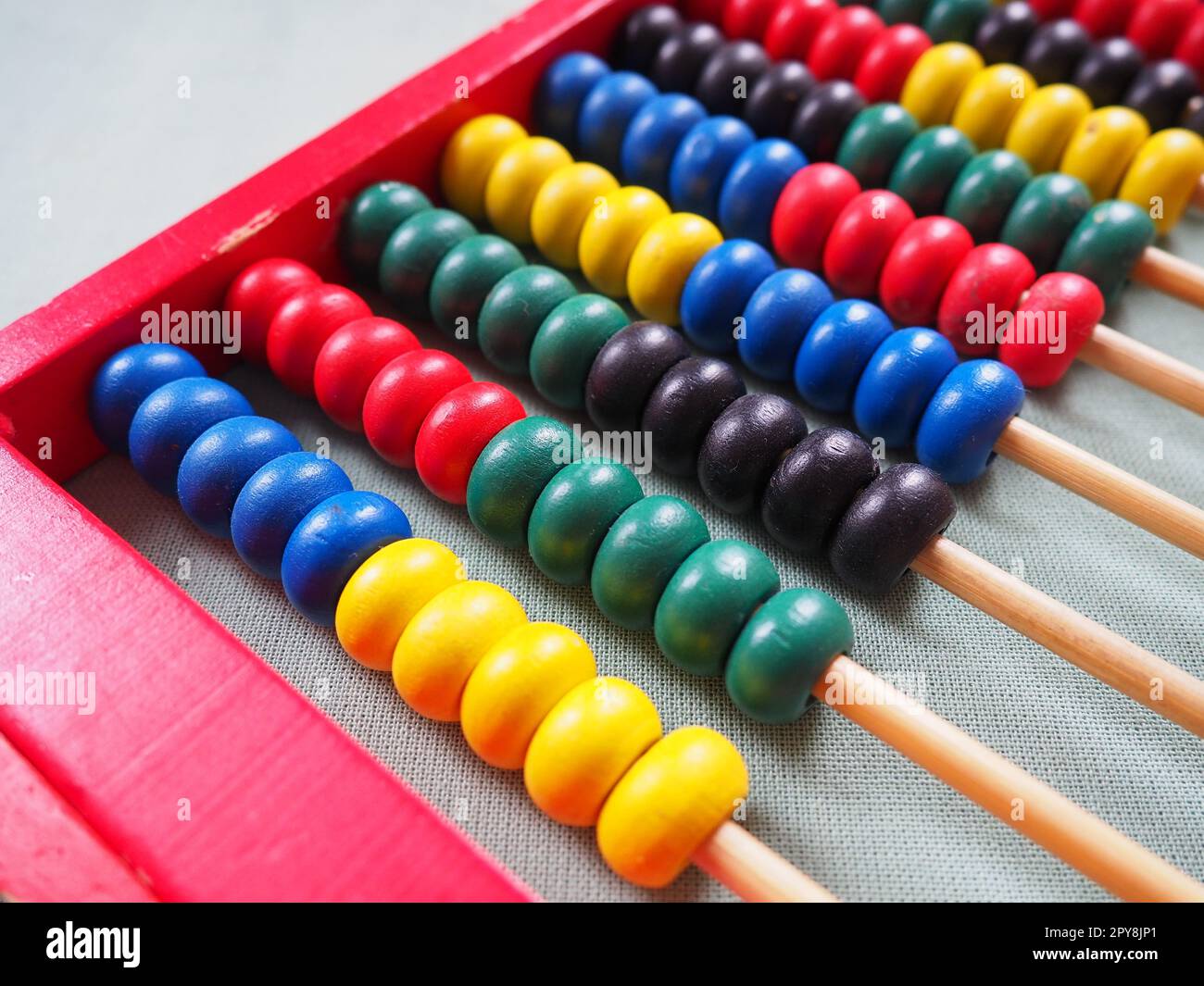 Concetto educativo - abaco con molte perle colorate. Dettagli rossi, blu, verdi, neri e gialli sull'abaco. Esercizi matematici. Programma scolastico Foto Stock