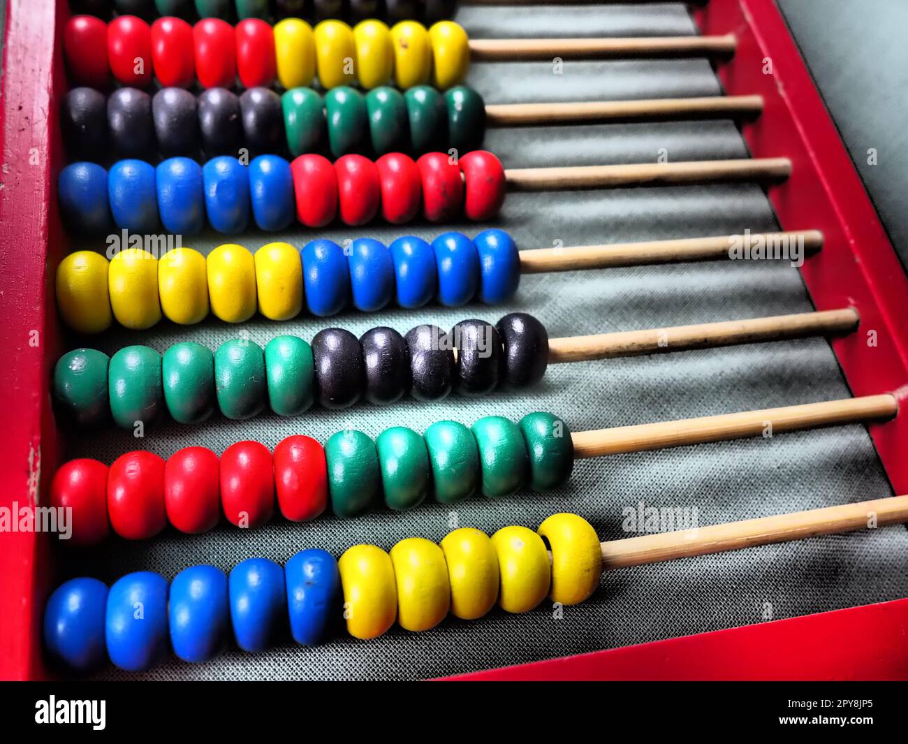Concetto educativo - abaco con molte perle colorate. Dettagli rossi, blu, verdi, neri e gialli sull'abaco. Esercizi matematici. Programma scolastico Foto Stock