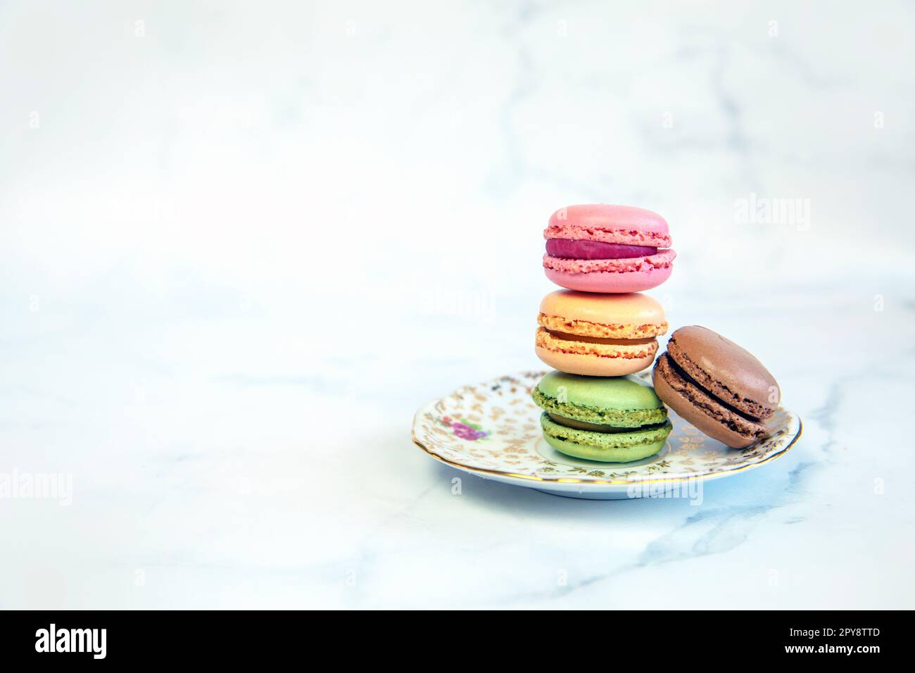 Macaron francesi colorati macaron pastello colorati su sfondo bianco pastello Macaron rosa e marrone con mirtillo fresco, torta dolce stack copia spazio Foto Stock