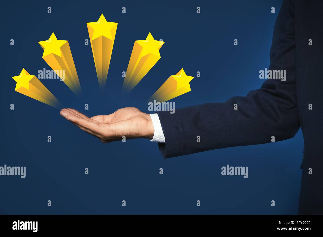 Uomo che mostra icone di cinque stelle su sfondo blu, primo piano. Valutazione della qualità Foto Stock