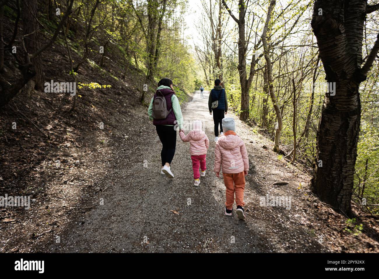 Schiena di madre con bambini piccoli escursioni all'aperto in primavera natura. Foto Stock