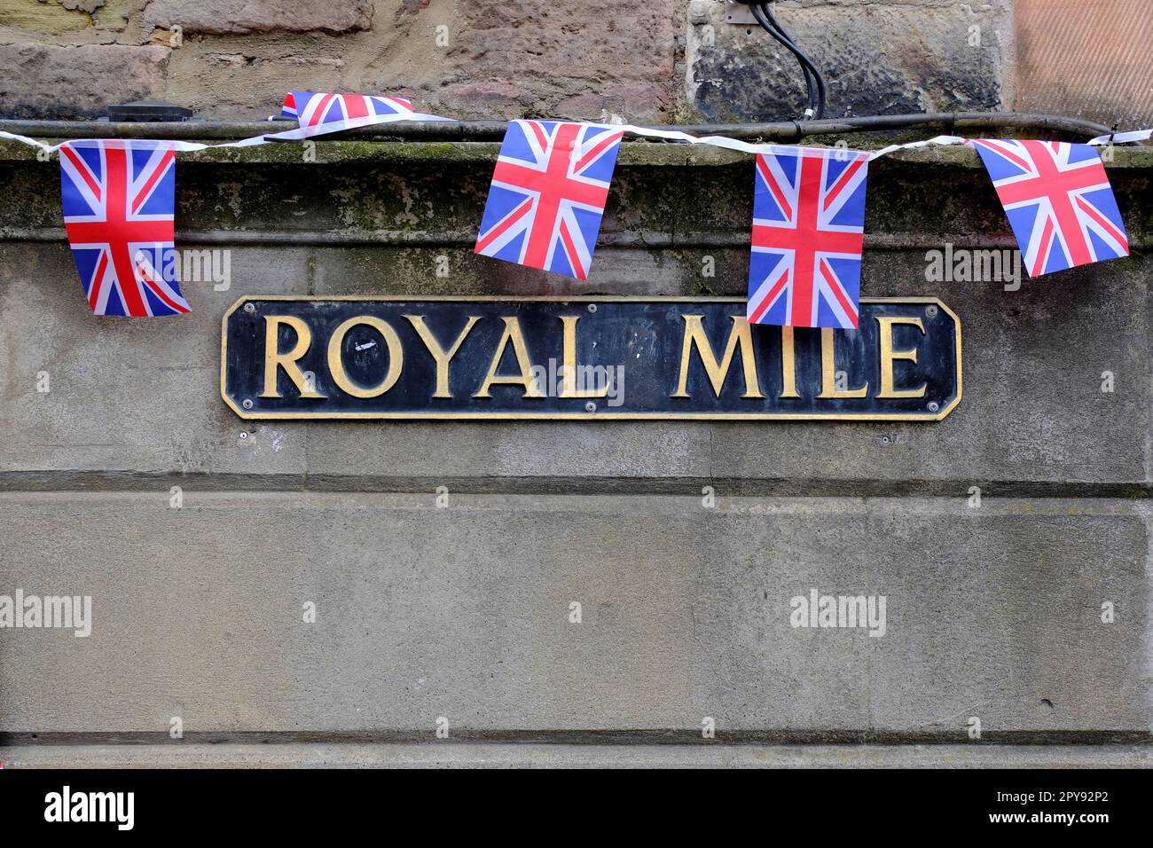 Edimburgo, Scozia, Regno Unito. 3rd maggio 2023. Preparativi per l'incoronazione di Re Carlo III sabato 6th maggio 2023, presso l'Abbazia di Westminster in pieno svolgimento lungo il Royal Mile. Union Jacks si è steso su un cartello stradale Royal Mile. Credit: Craig Brown/Alamy Live News Foto Stock