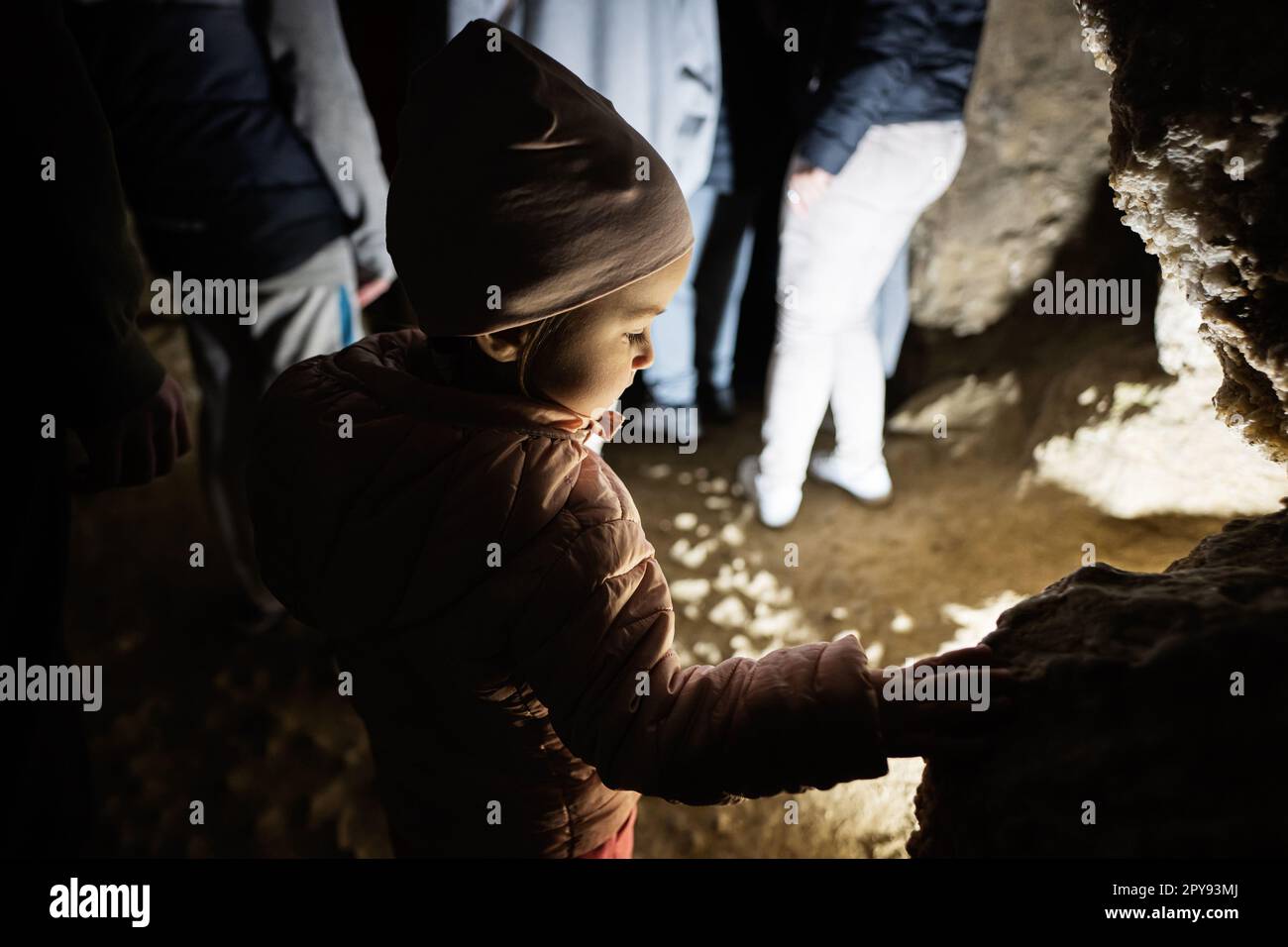 Bambina che cammina nella grotta ed esplora. Foto Stock