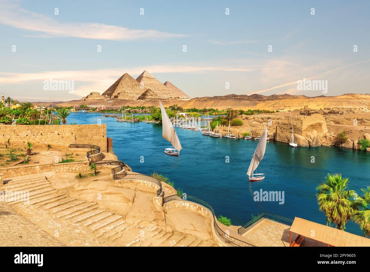 Barche a vela e rocce antiche nel Nilo sulla strada per le piramidi, Assuan, Egitto Foto Stock