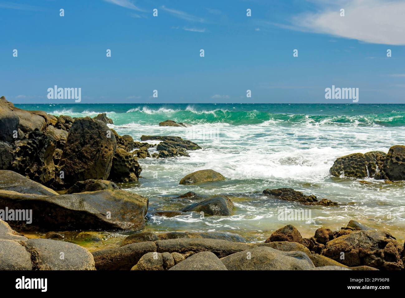 Spiaggia rocciosa e le sue onde sulla costa della città di Salvador a Bahia nella regione nord-orientale del Brasile, Brasile Foto Stock