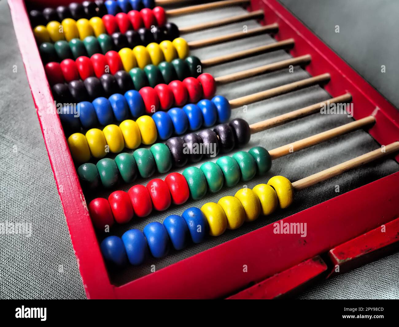 Concetto educativo - abaco con molte perle colorate. Dettagli rossi, blu, verdi, neri e gialli sull'abaco. Esercizi matematici. Programma scolastico Foto Stock