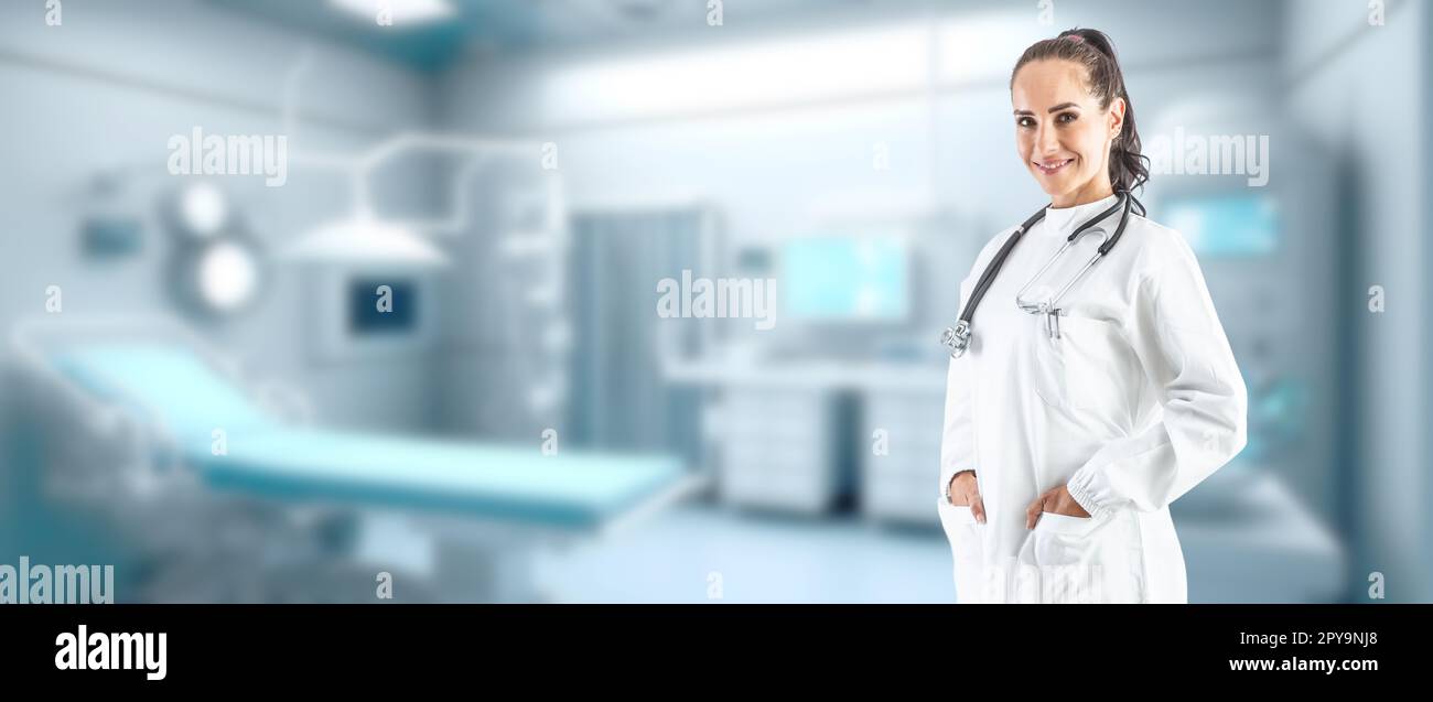 Sorridente medico femminile in un cappotto bianco con uno stetoscopio sullo sfondo di un moderno defocused ambulanza interno - Copia spazio. Foto Stock