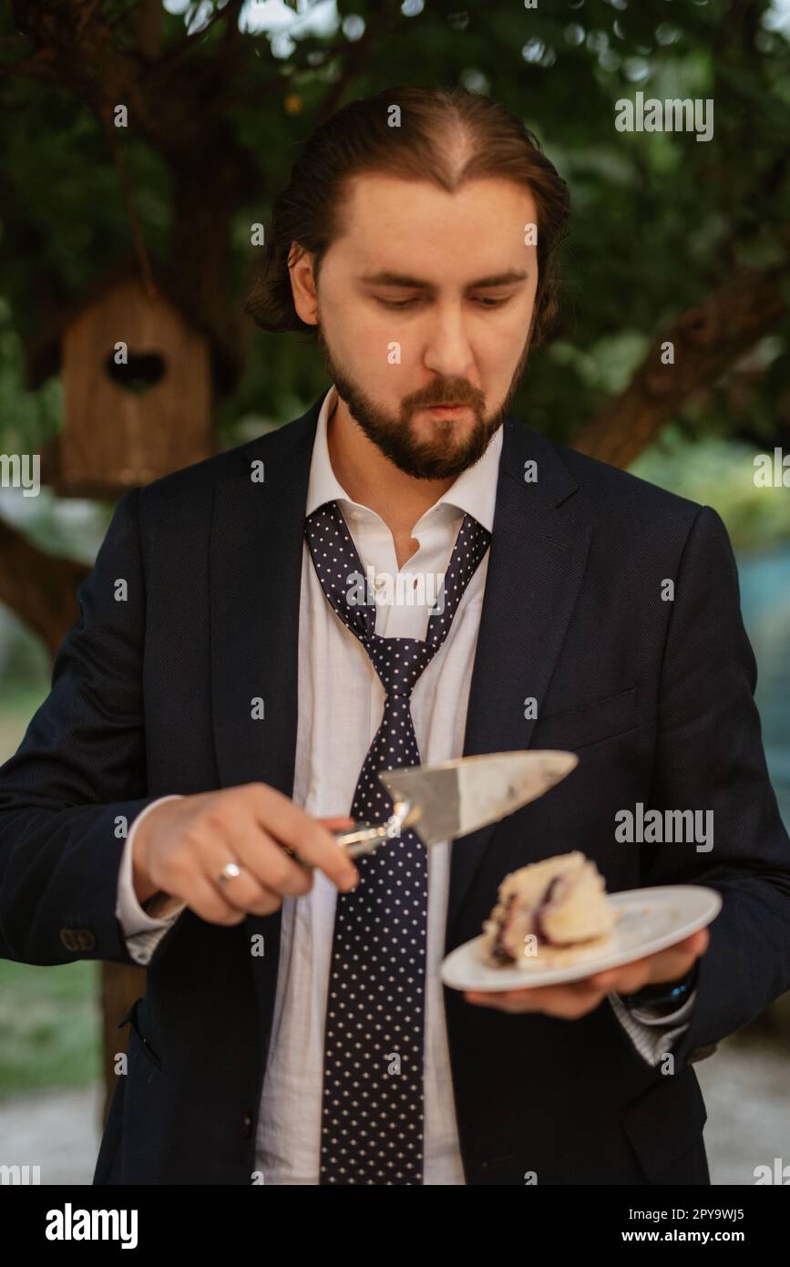 gli sposi novelli tagliano e assaggiano la torta nuziale Foto Stock