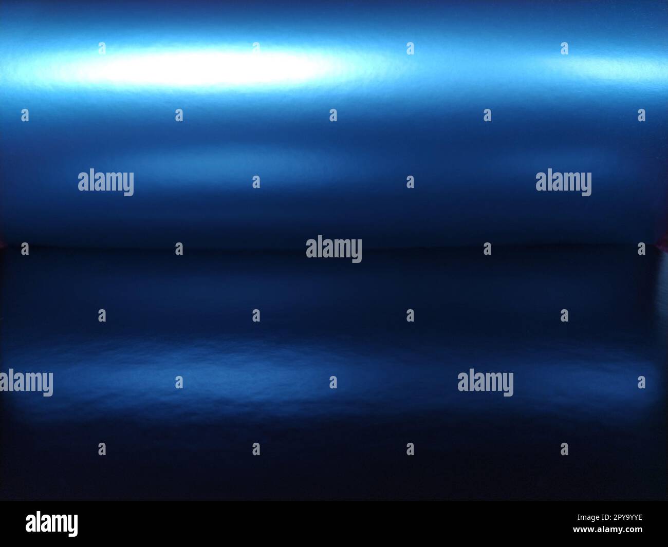 Sfumatura su sfondo blu. Carta lucida piegata orizzontalmente o foglio con trabocco ed evidenziazioni. Misteriosa luminosità. Aurora boreale. Tessuto di lusso. Brillantezza metallizzata. Illuminato Foto Stock