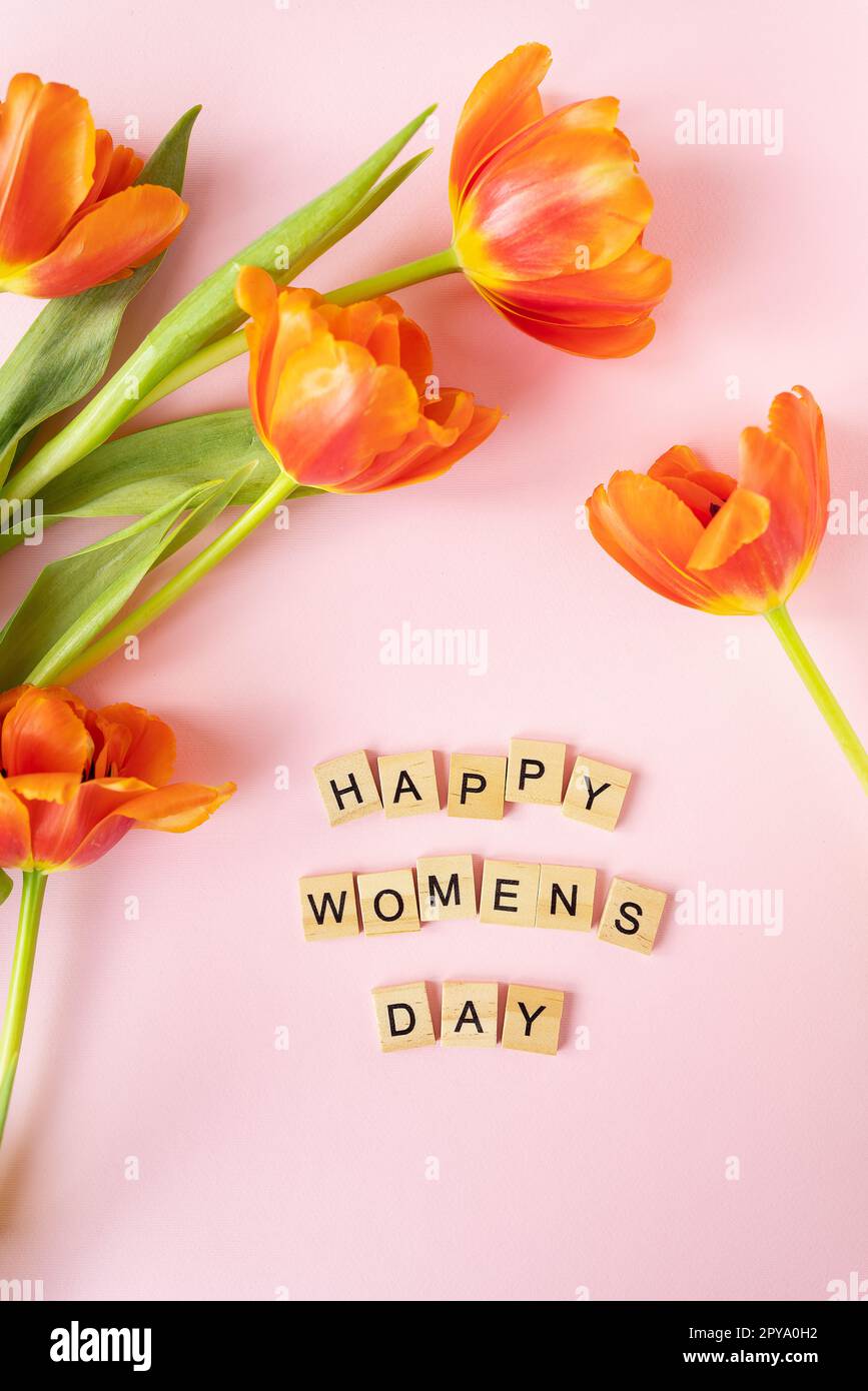 8 marzo, cartolina. Cartello di testo Happy Women's Day su sfondo tulipani arancione. Elegante e piatta, con fiori, testo e biglietto d'auguri. Foto Stock