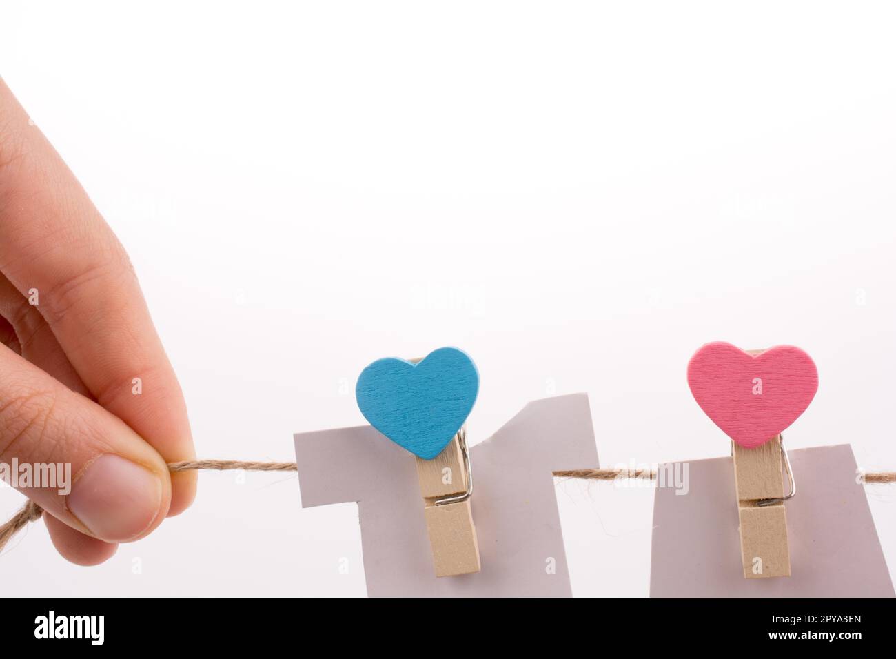 Hearted clothespins appeso a una fune sottile Foto Stock