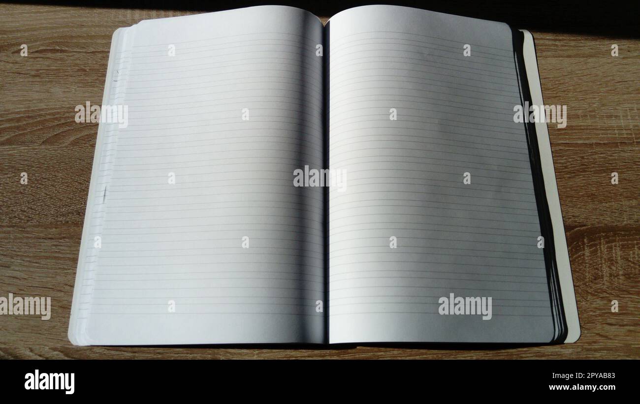 Notebook con inversione a U e pagine bianche vuote. Luce solare naturale dura Foto Stock