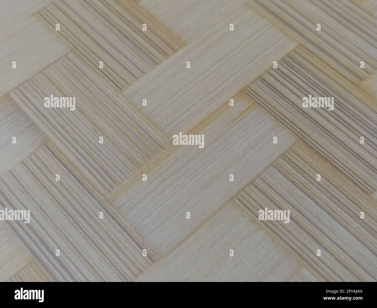 Frammento di pavimento in parquet. Motivo parquet. Interlacciamento di elementi. Superficie in legno, bambù o paglia. Tappetino caldo. Primo piano. Foto Stock