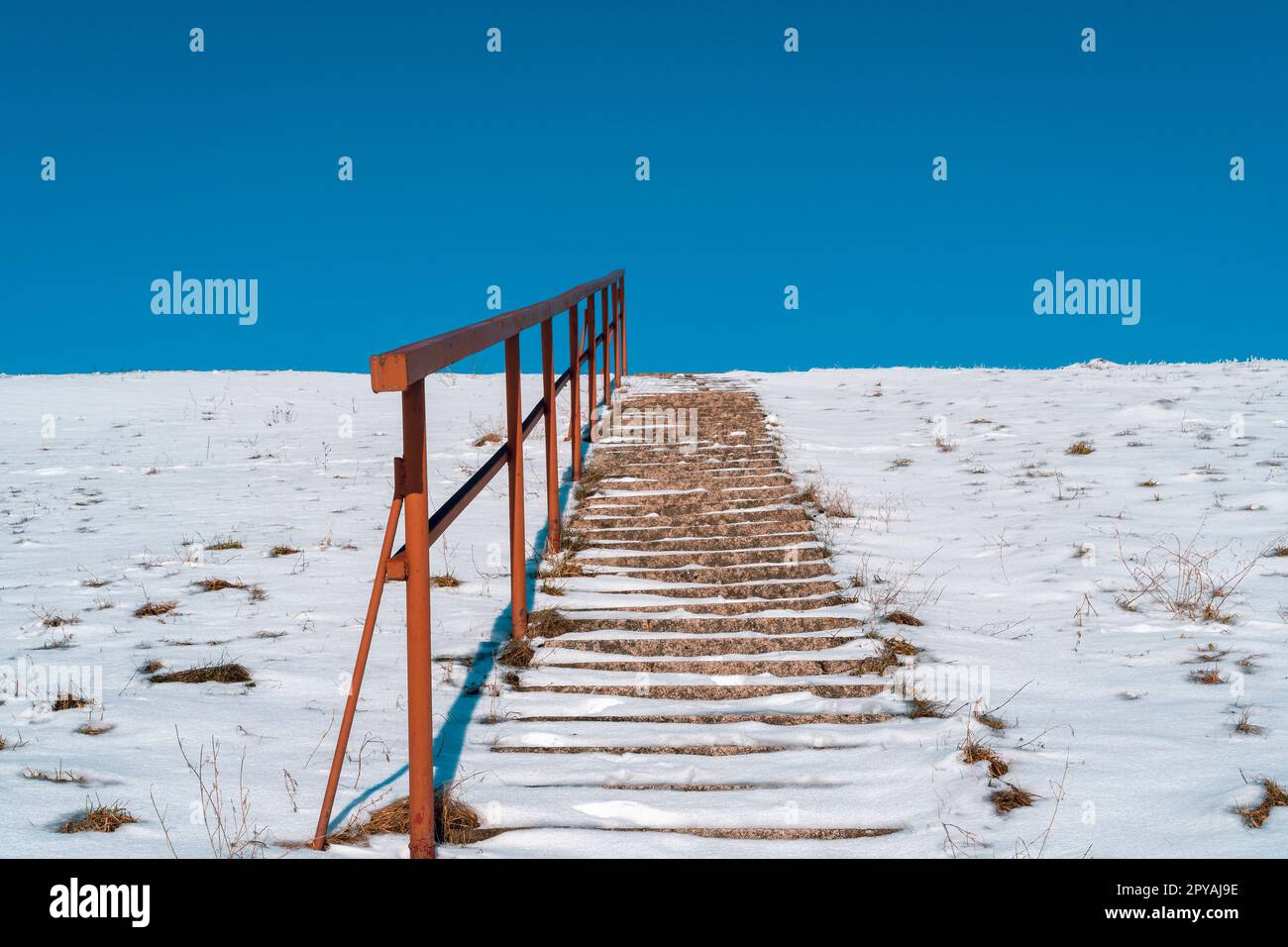 Scale che si estendono fino a una collina con neve che si scioglie Foto Stock