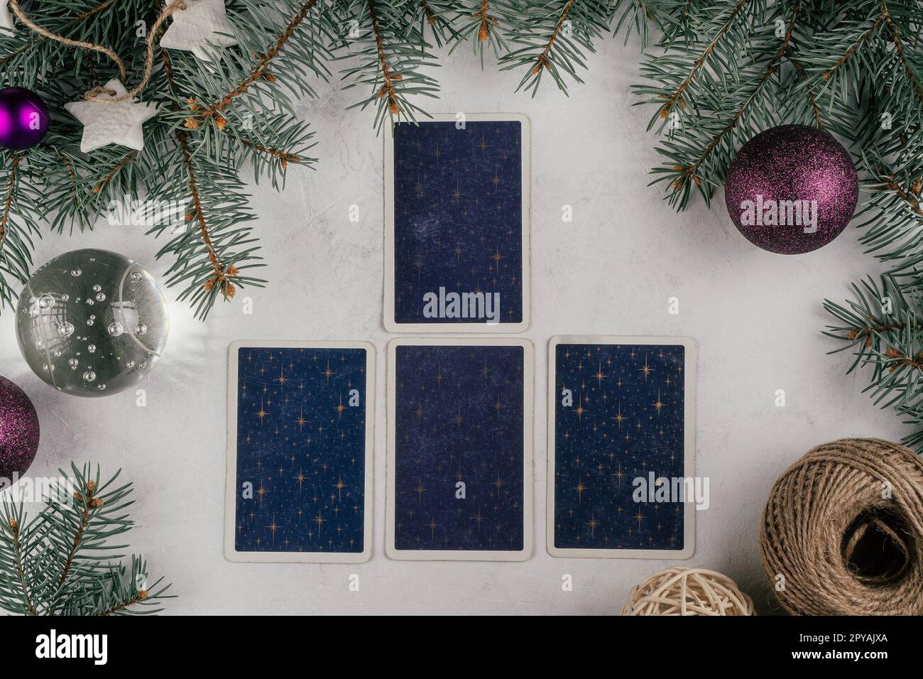 Carte di tarocchi spalmate su una superficie bianca di cemento con rami di alberi di Natale e candele. Minsk, Bielorussia, 19.11.2021 Foto Stock