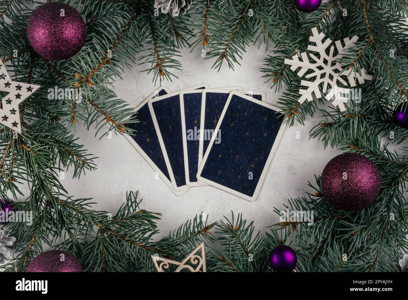 Le carte di Tarocchi risaltano su una superficie bianca in cemento con rami e decorazioni per alberi di Natale. Minsk, Bielorussia, 19.11.2021 Foto Stock