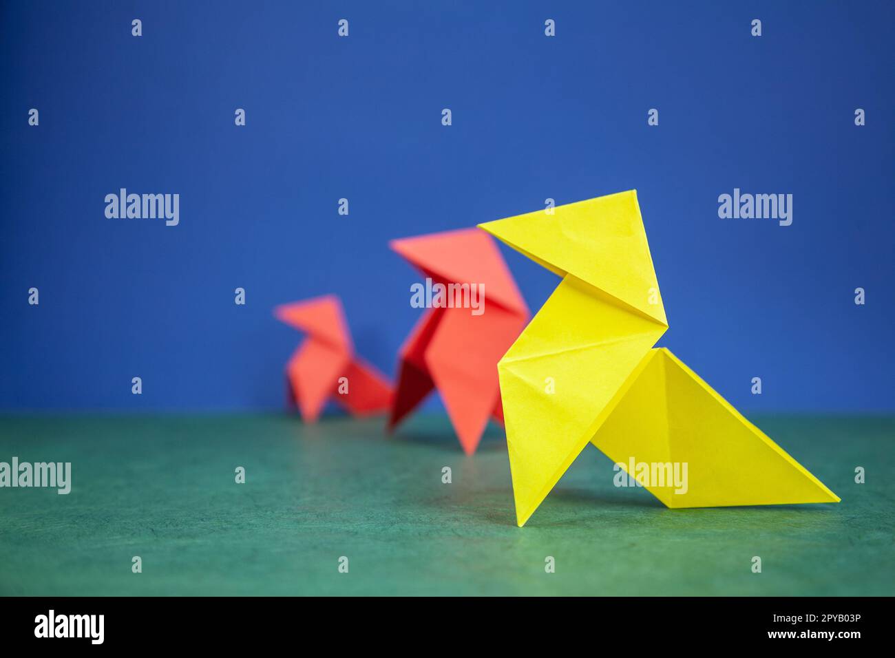 Carta hen origami su sfondo verde e blu Foto Stock