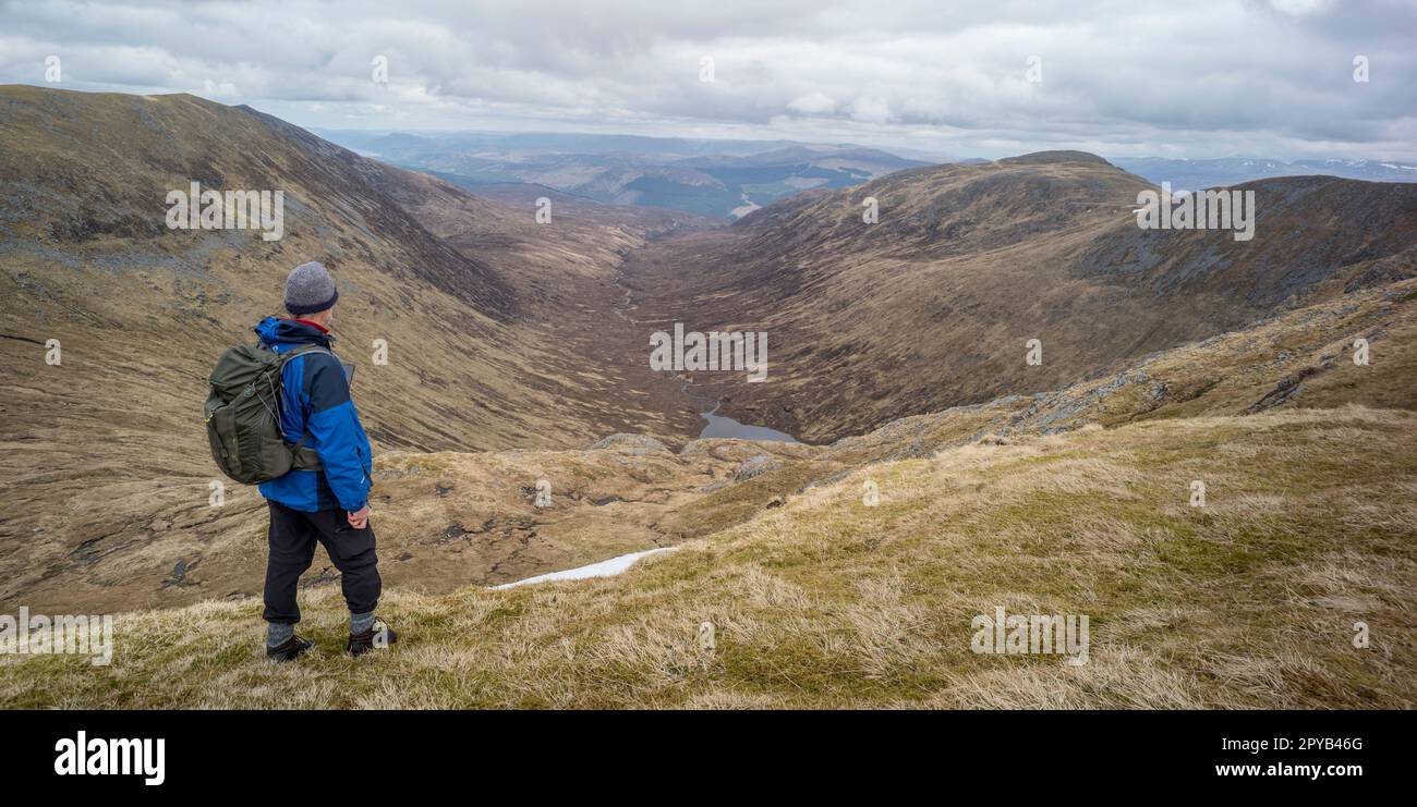 Un escursionista si affaccia su Corie Glas o Loch un ghlais choire da Sron a choire Ghairbh Munro. La valle sarà allagata per lo schema di stoccaggio delle pompe idrostatiche Foto Stock