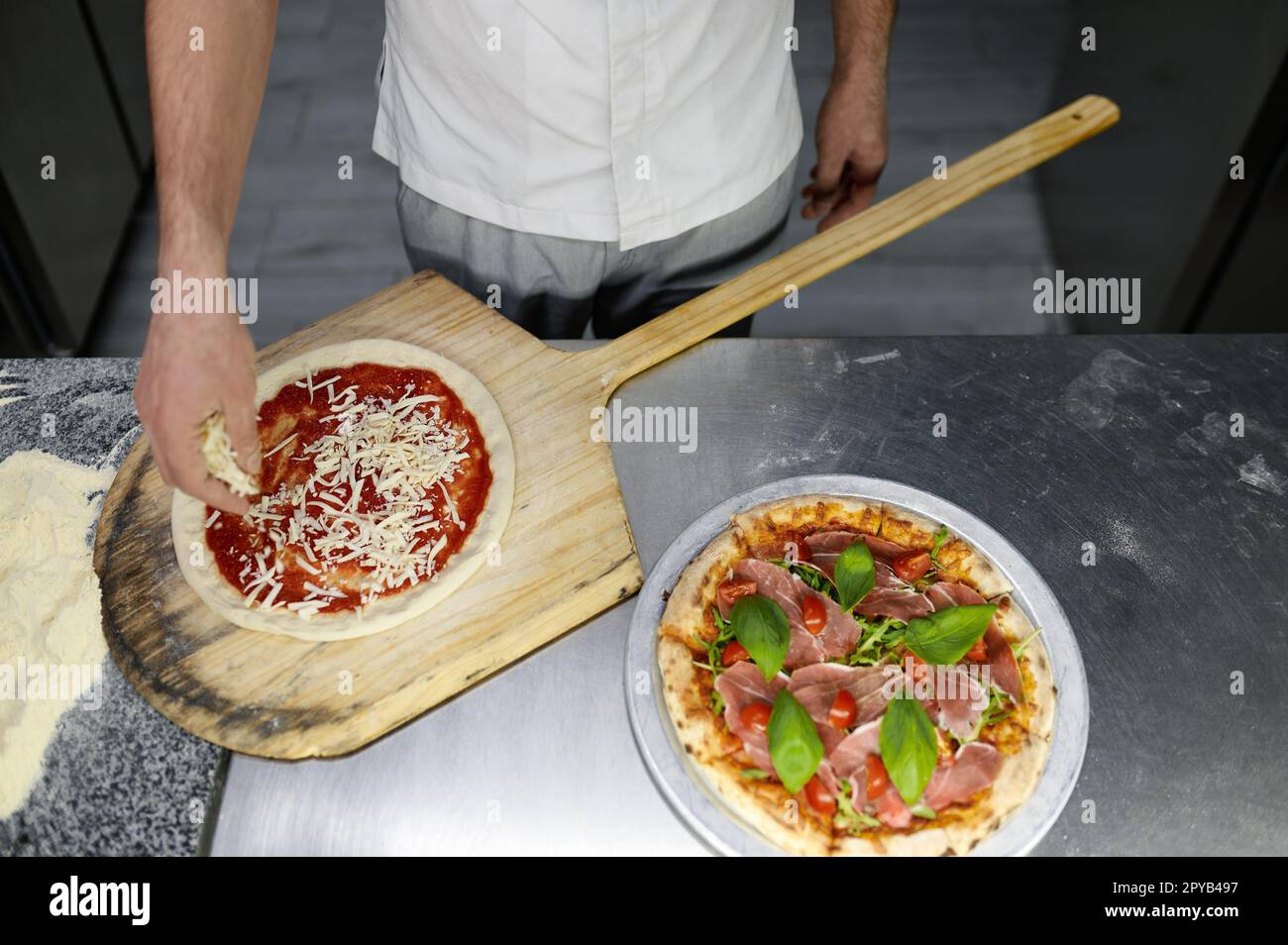 Vista dall'alto sullo chef che prepara la pizza base su cucina professionale Foto Stock