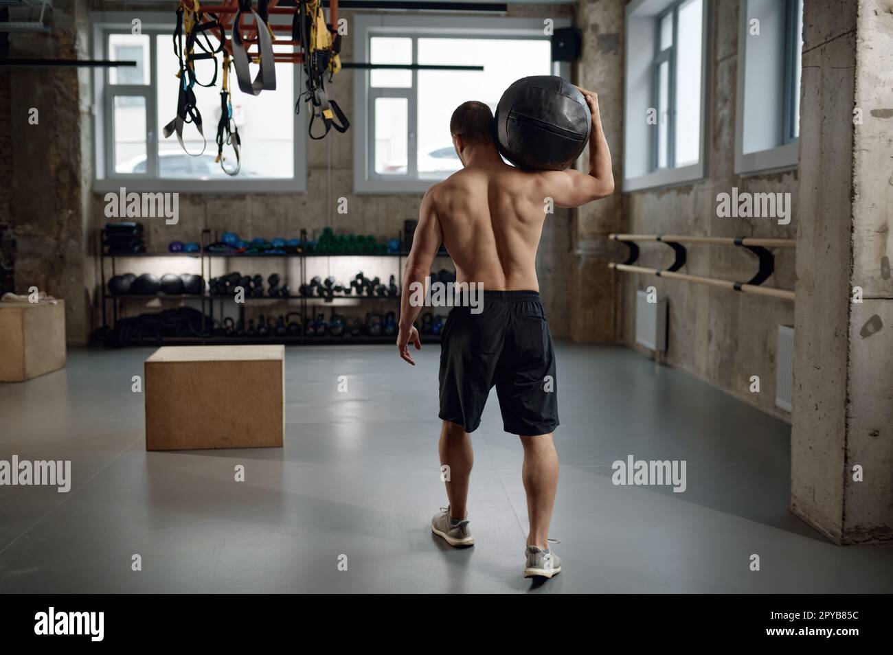 Ritratto dell'atleta maschile che tiene la palla medica sulla spalla dopo l'allenamento funzionale Foto Stock
