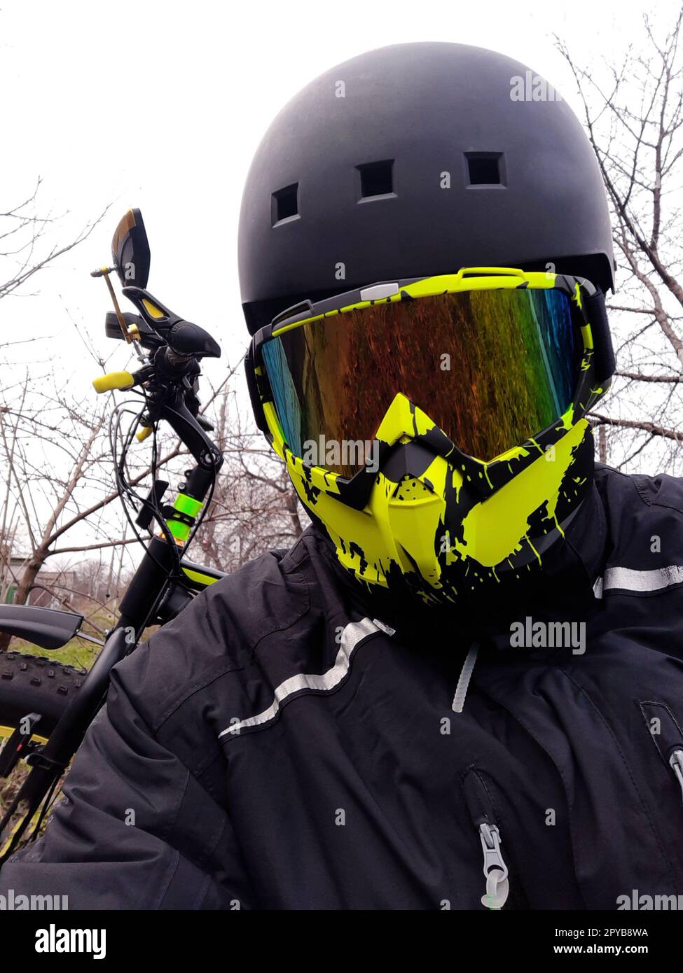 Ciclista con casco e maschera sullo sfondo di una fatbike Foto Stock