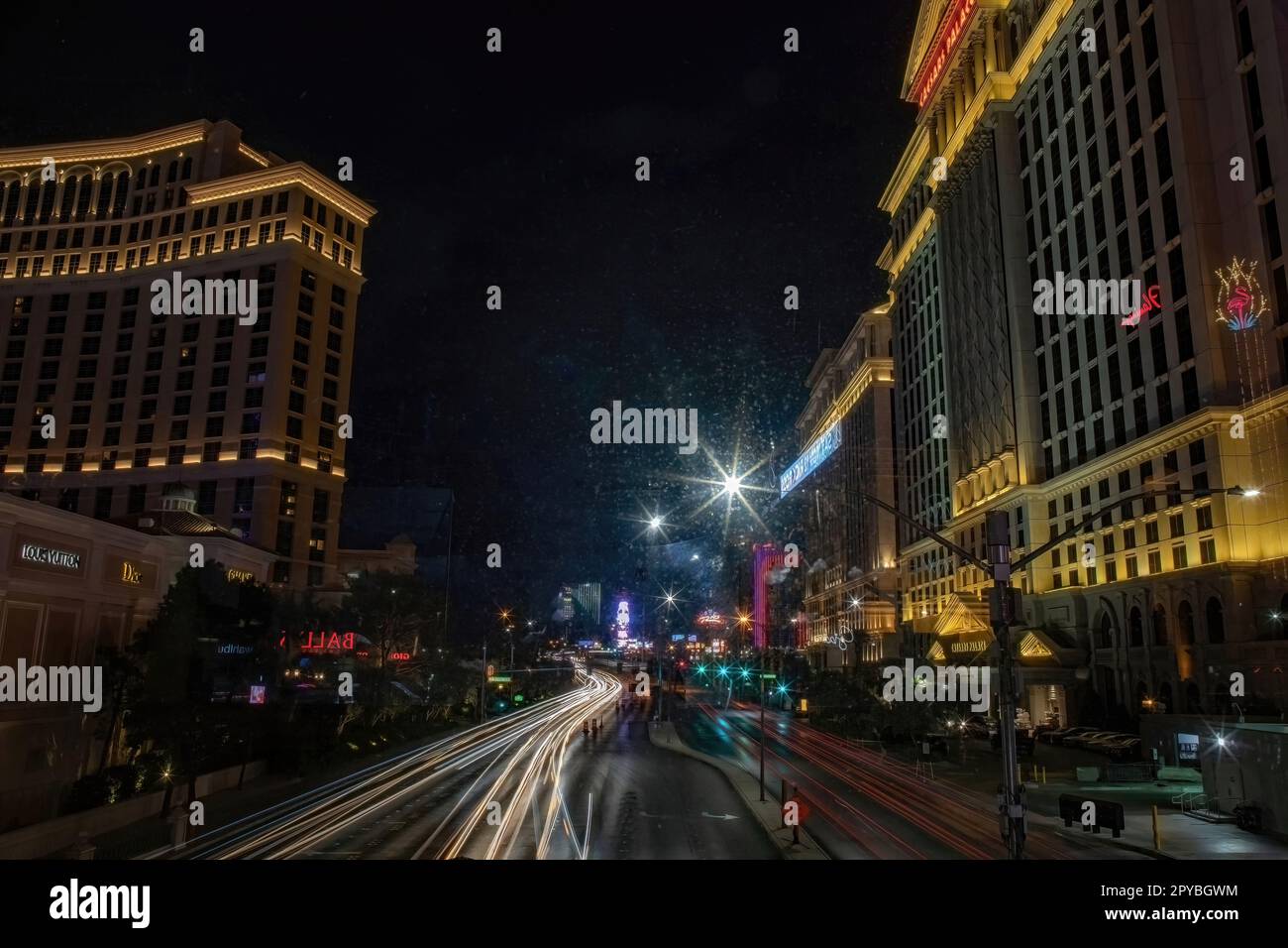 La velocità dell'otturatore rallenta e le luci dell'auto si accendono di notte su E. Flamingo Rd. Vicino a Las Vegas Blvd., con Caesars Palace Resort and Casino a Las Vegas, Nevada USA. Foto Stock