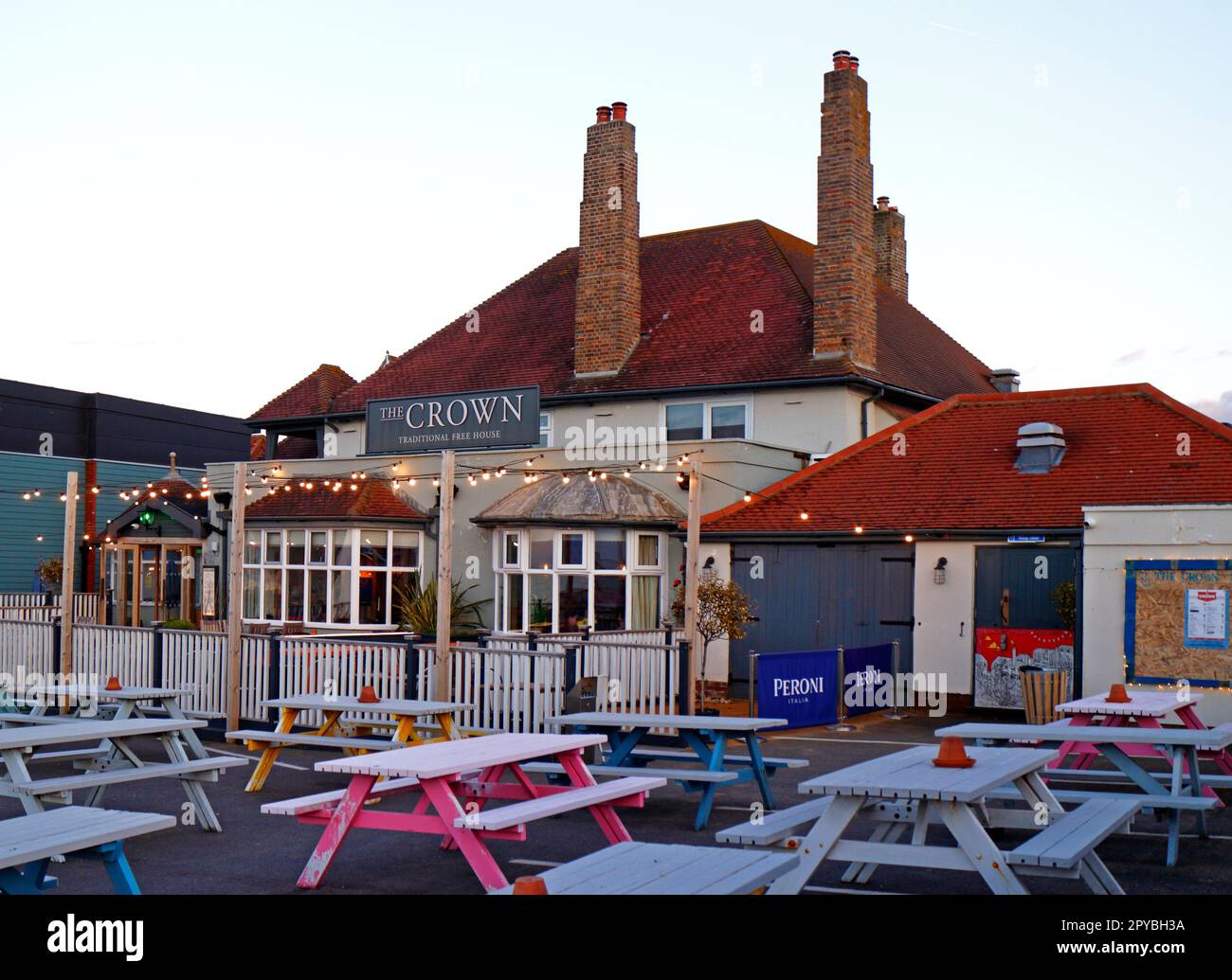 Una vista del Crown inn con posti a sedere all'esterno che si affaccia sulla spiaggia e sul mare sulla costa nord del Norfolk a Sheringham, Norfolk, Inghilterra, Regno Unito. Foto Stock