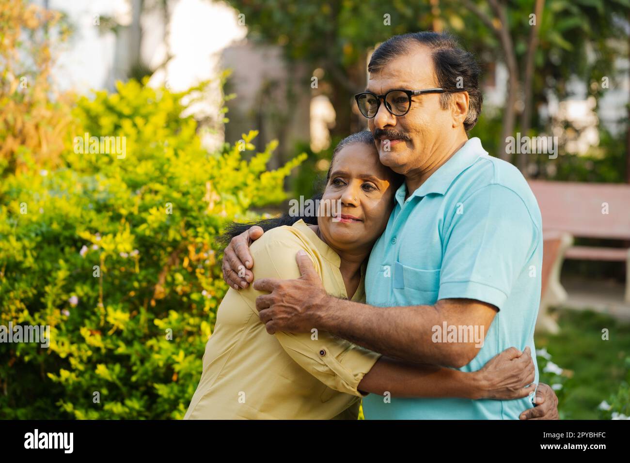 Donna anziana indiana felice abbracciando o abbracciando il marito tenendo a stretto contatto con la copia spazio - concetto di compagno, sicuro e confortevole Foto Stock