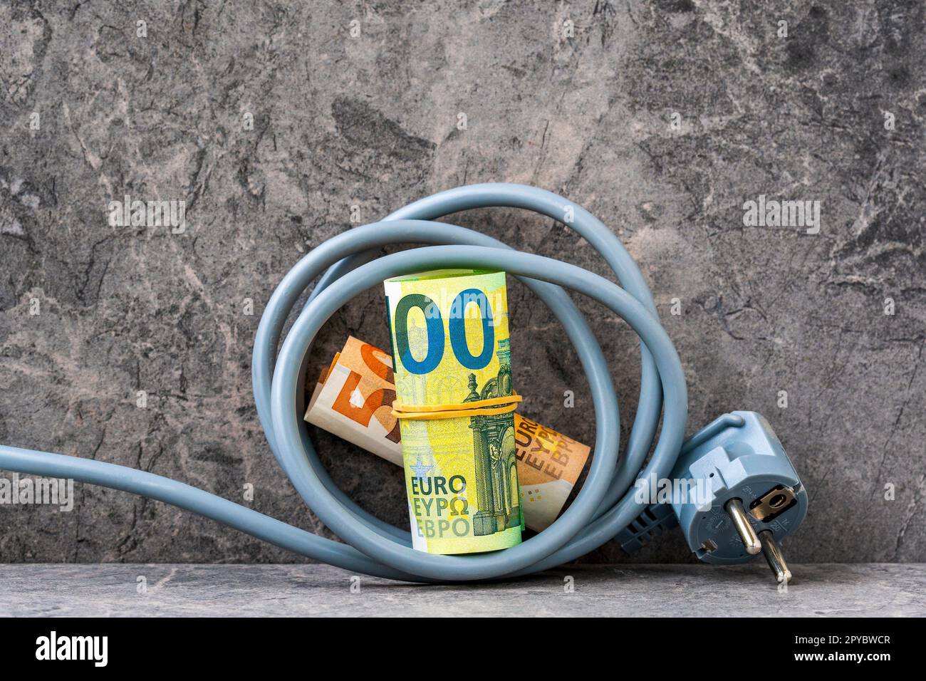 Cavo elettrico con rotoli di valuta europea Foto Stock