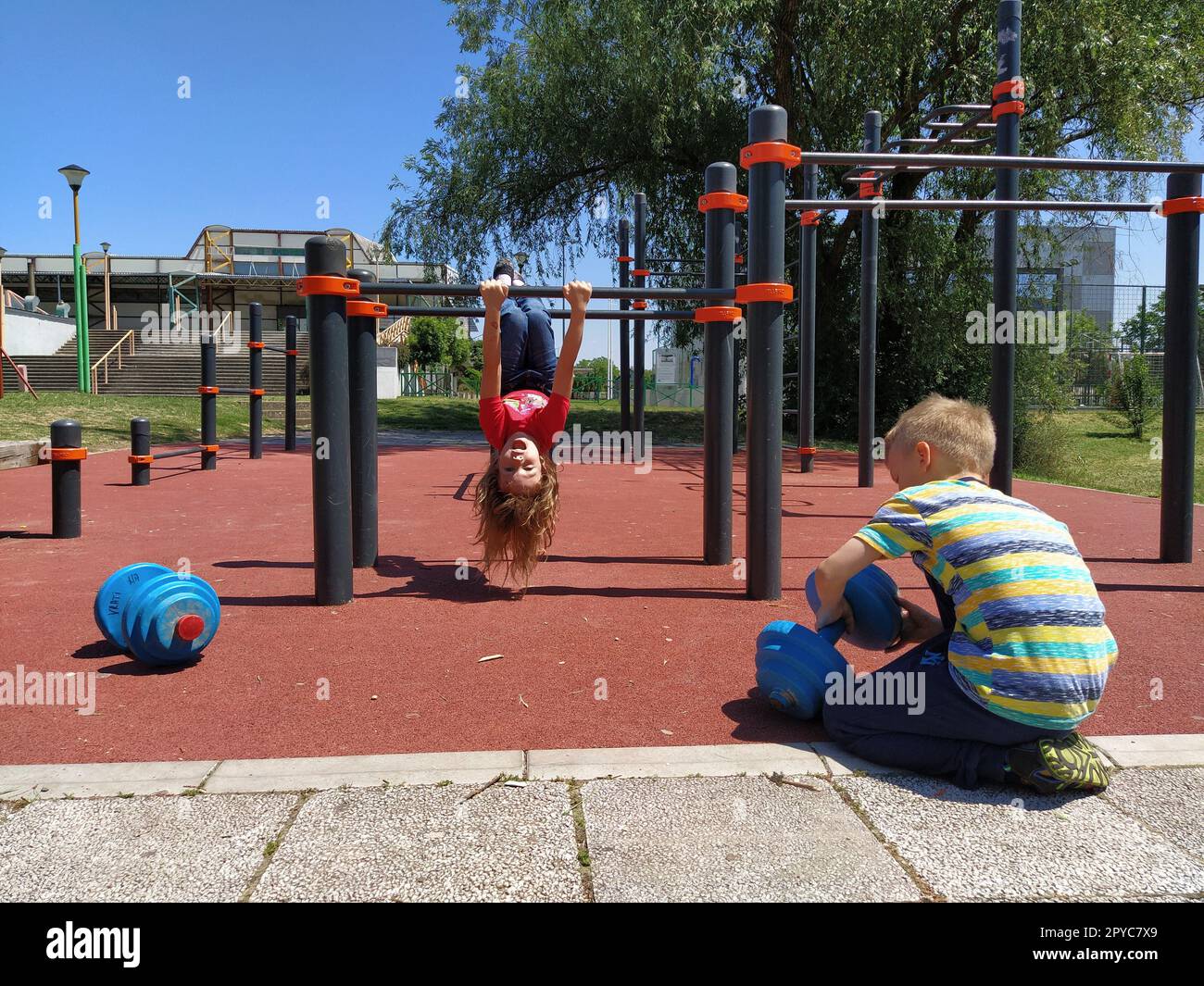 6 giugno 2020, Sremska Mitrovica, Serbia. I bambini vanno a fare sport nel parco giochi. Esercizi con kettlebell. Pesi di sollevamento. Educazione fisica e sport. Divertimento per bambini in estate Foto Stock