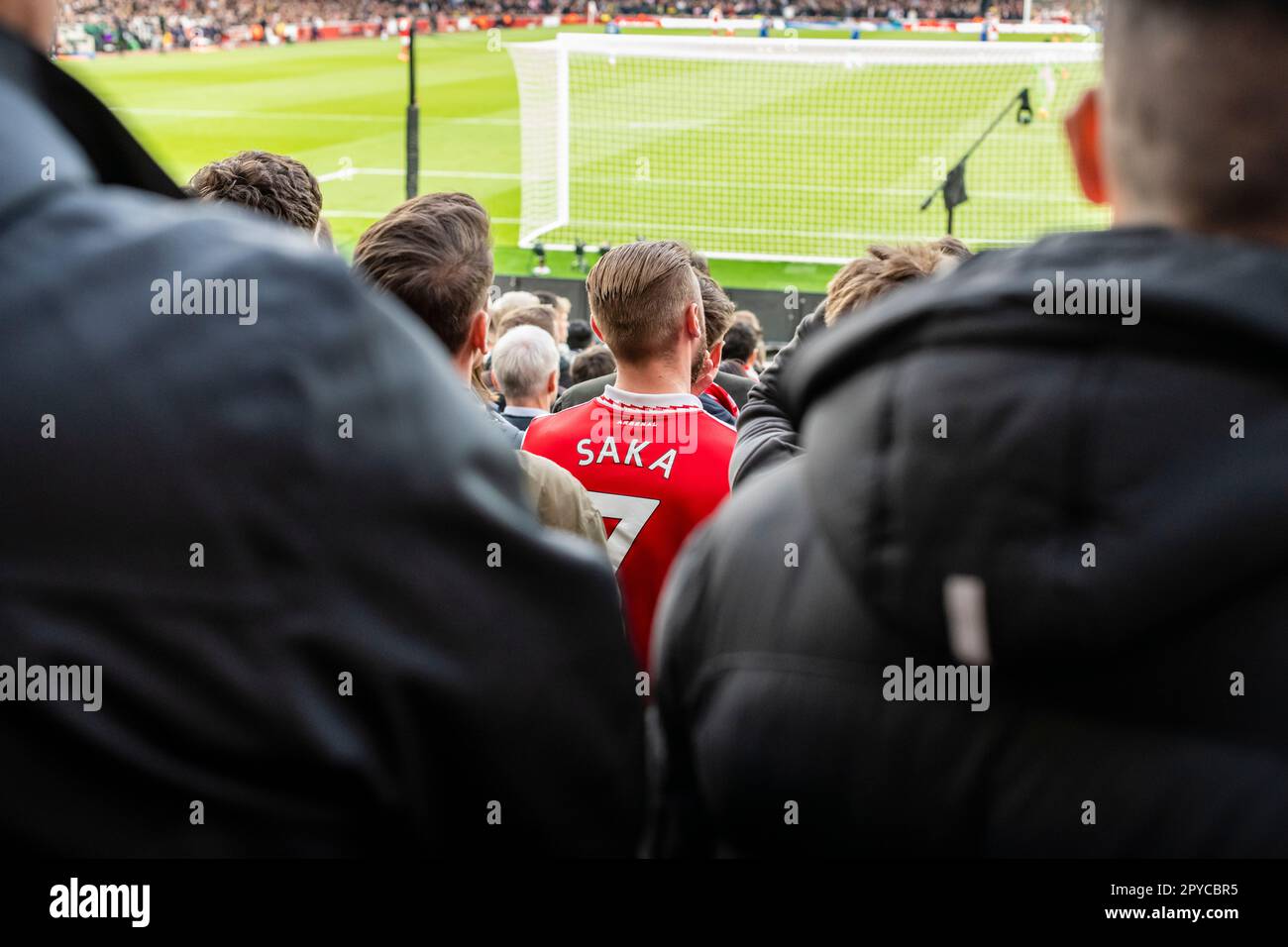 Giovane uomo in folla ad una partita di calcio con la maglia Saka, l'Arsenal Football Club, lo stadio Emirates di Londra Foto Stock