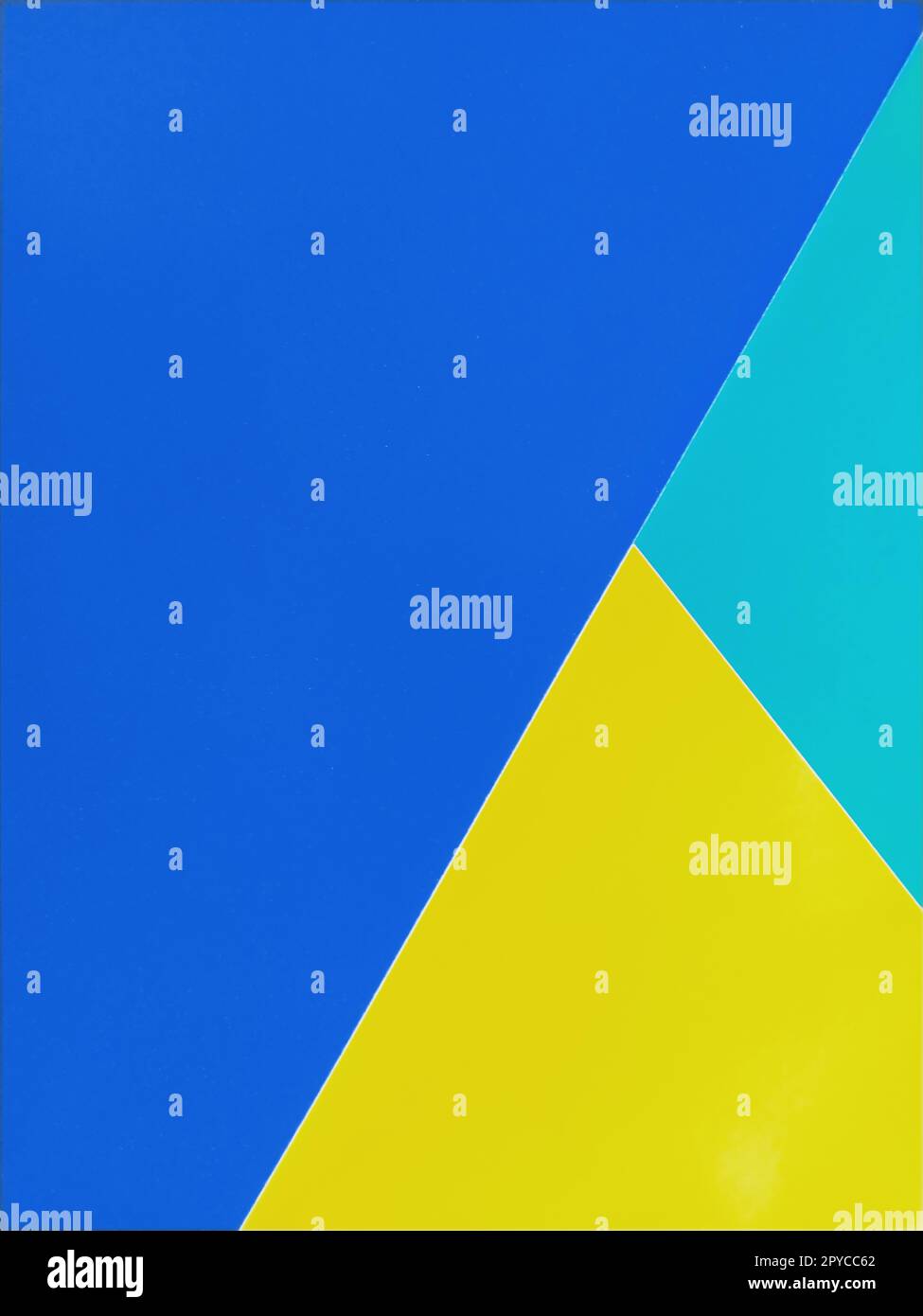 Carta di colore blu, verde e giallo impilata l'una sull'altra. Sfondo colorato Foto Stock