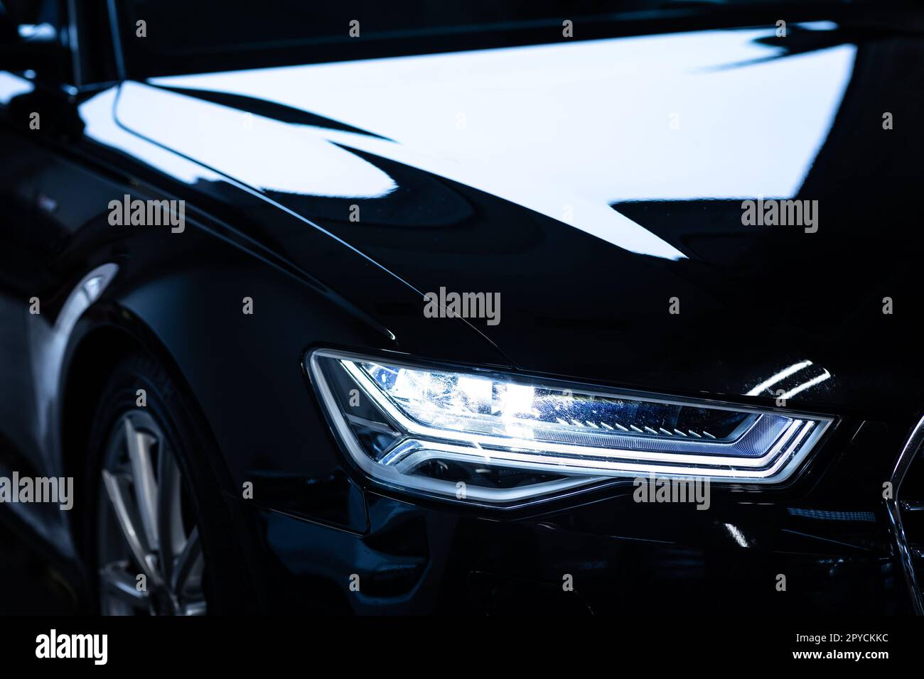 Auto moderna in un'officina di dettaglio su cui lavorare, decontaminata, cerata, lucidata, rifinita alla perfezione Foto Stock