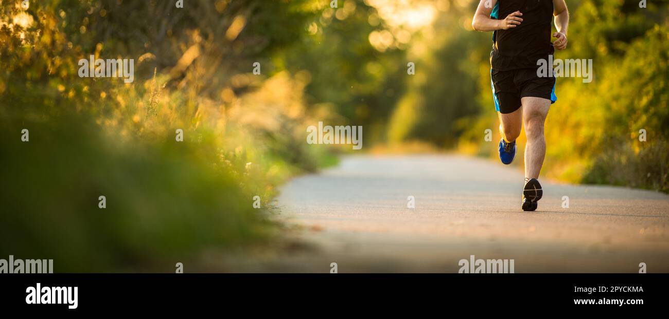 Scatto di un giovane atleta maschile allenamento. Ottenere la sua dose giornaliera di miglia, per rimanere in forma e magro. Foto Stock