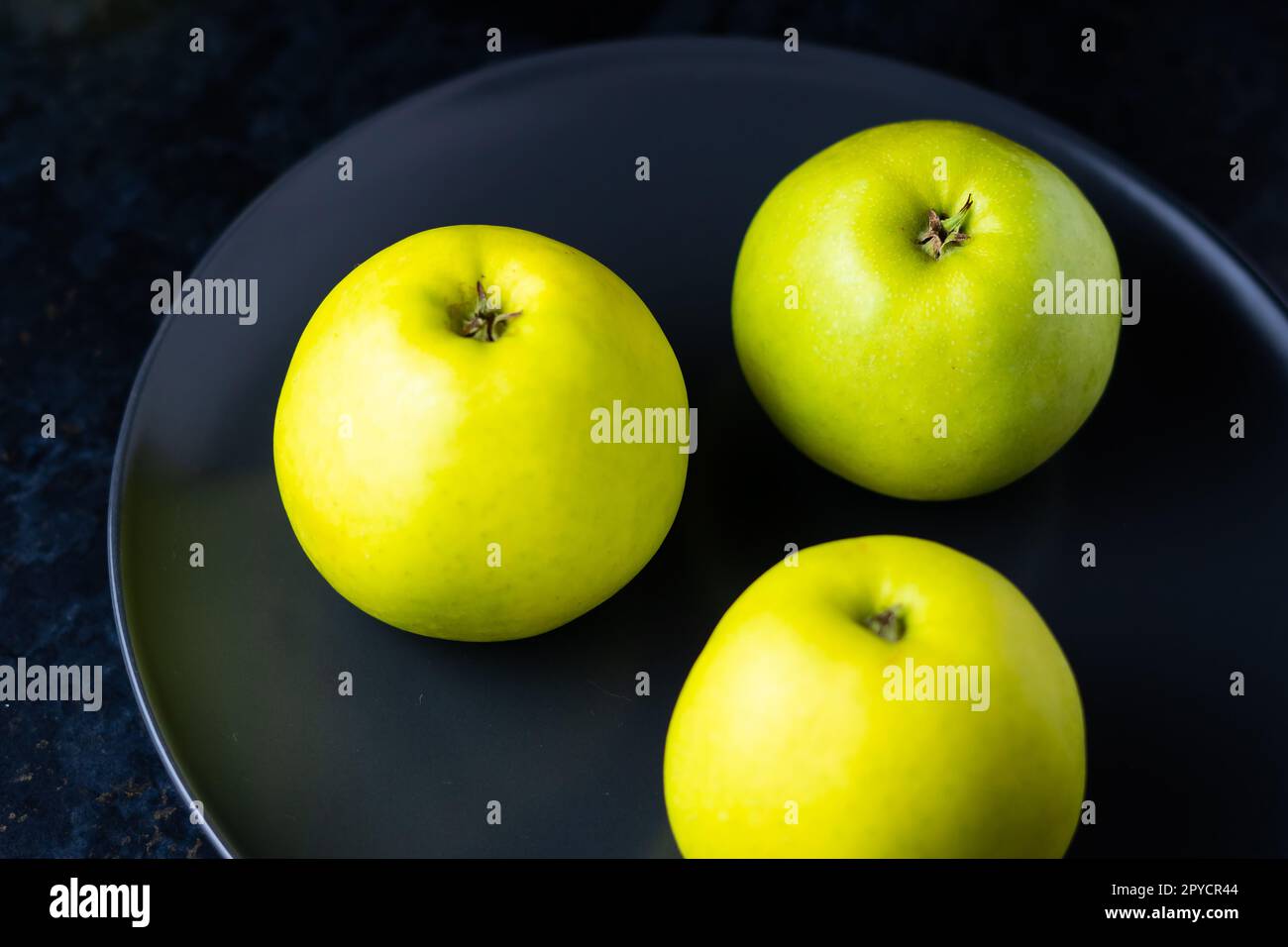 Frutti di mela verde maturi su tavolo di pietra scura. Vista dall'alto con spazio di copia. Disposizione piatta Foto Stock