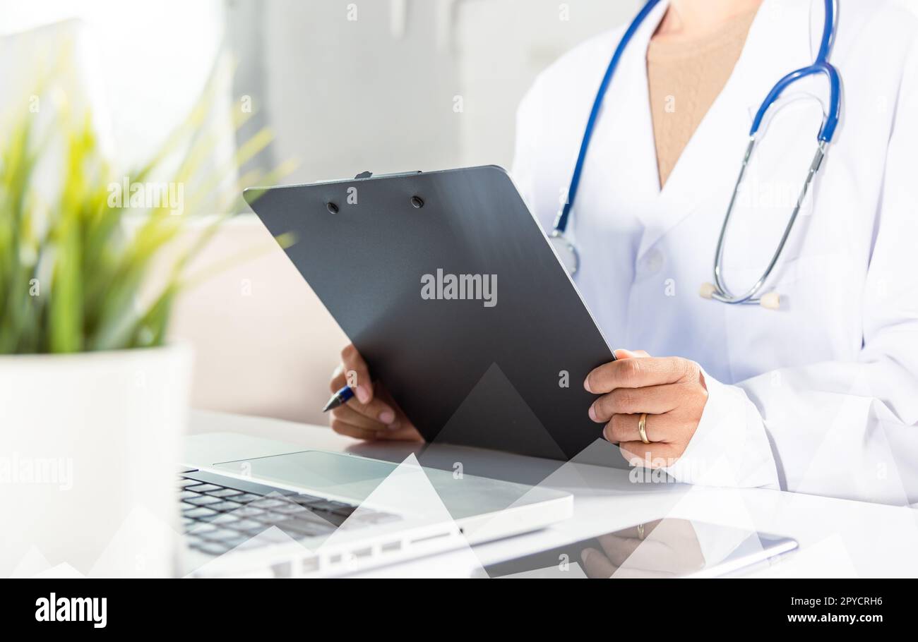 medico donna in uniforme con stetoscopio scrivere informazioni di prescrizione del paziente in documentazione Foto Stock