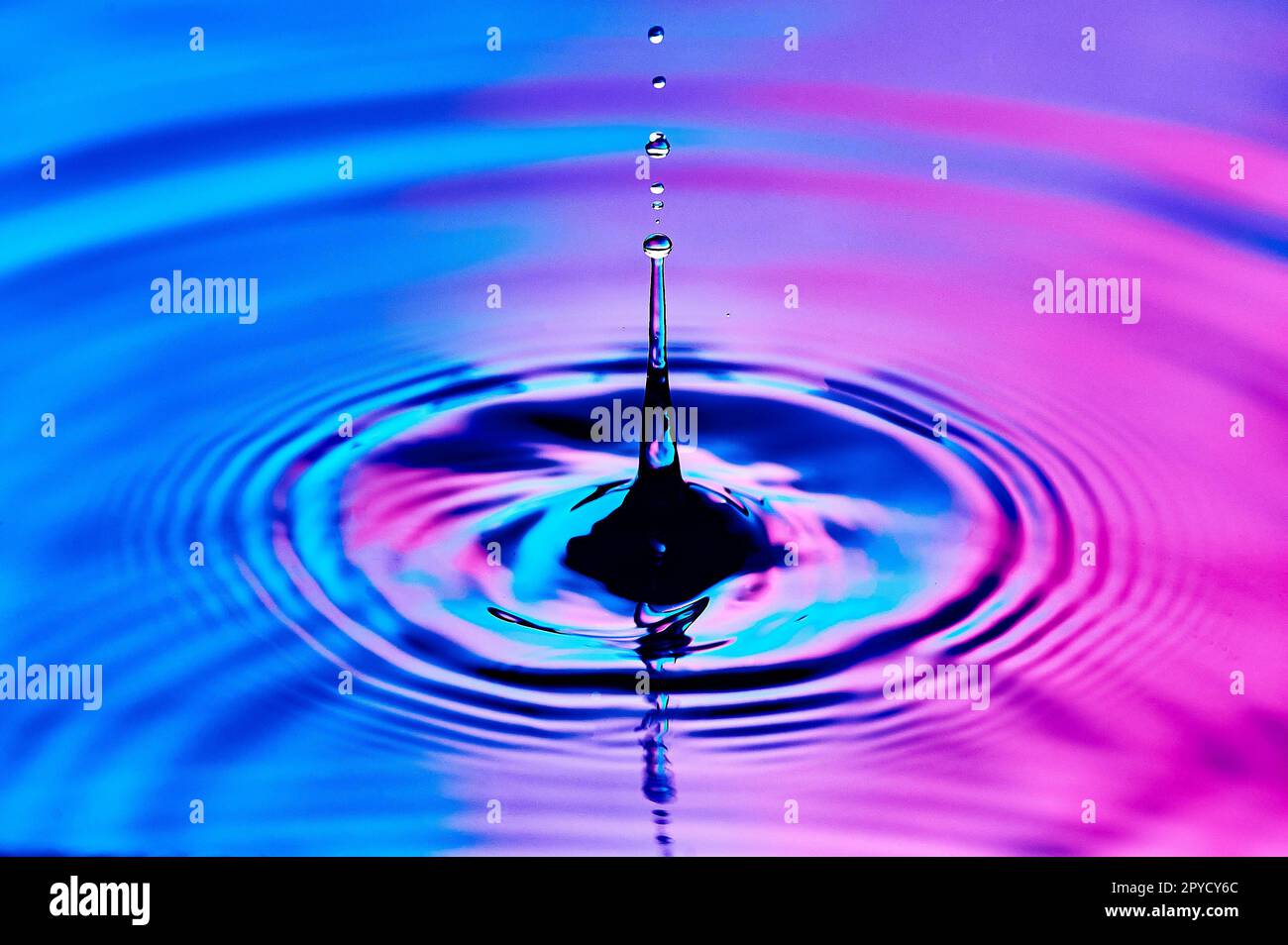 una goccia d'acqua che cade nell'acqua e crea onde Foto Stock