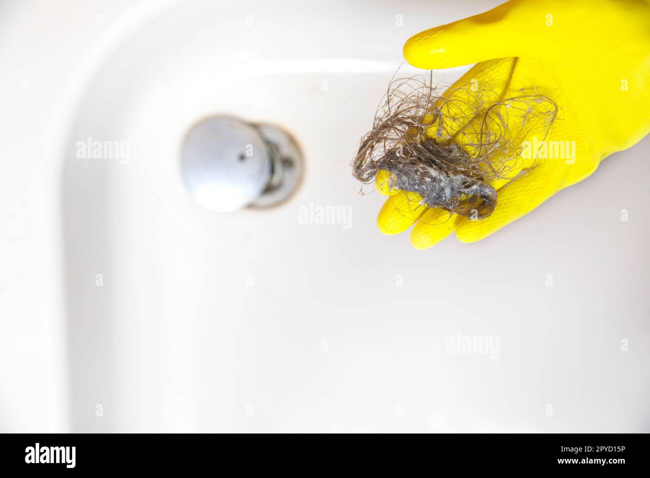 Lo scarico della doccia è ostruito con i capelli, perdita del pelo dei capelli in un bagno dopo il lavaggio dei capelli nella doccia, pulizia del bagno e rimozione della vista superiore dei capelli Foto Stock