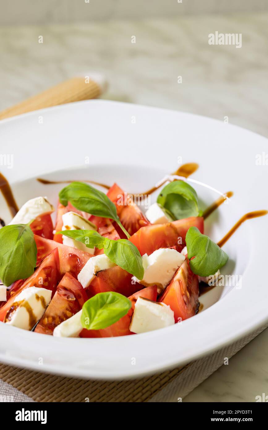 insalata di pomodoro con mozzarella, basilico e crema balsamica Foto Stock