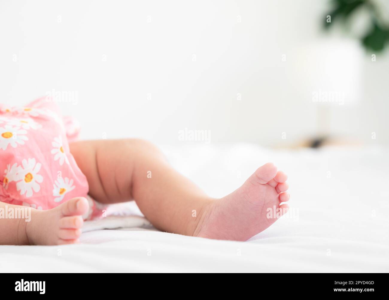 I piedi del piccolo neonato sul letto di casa Foto Stock