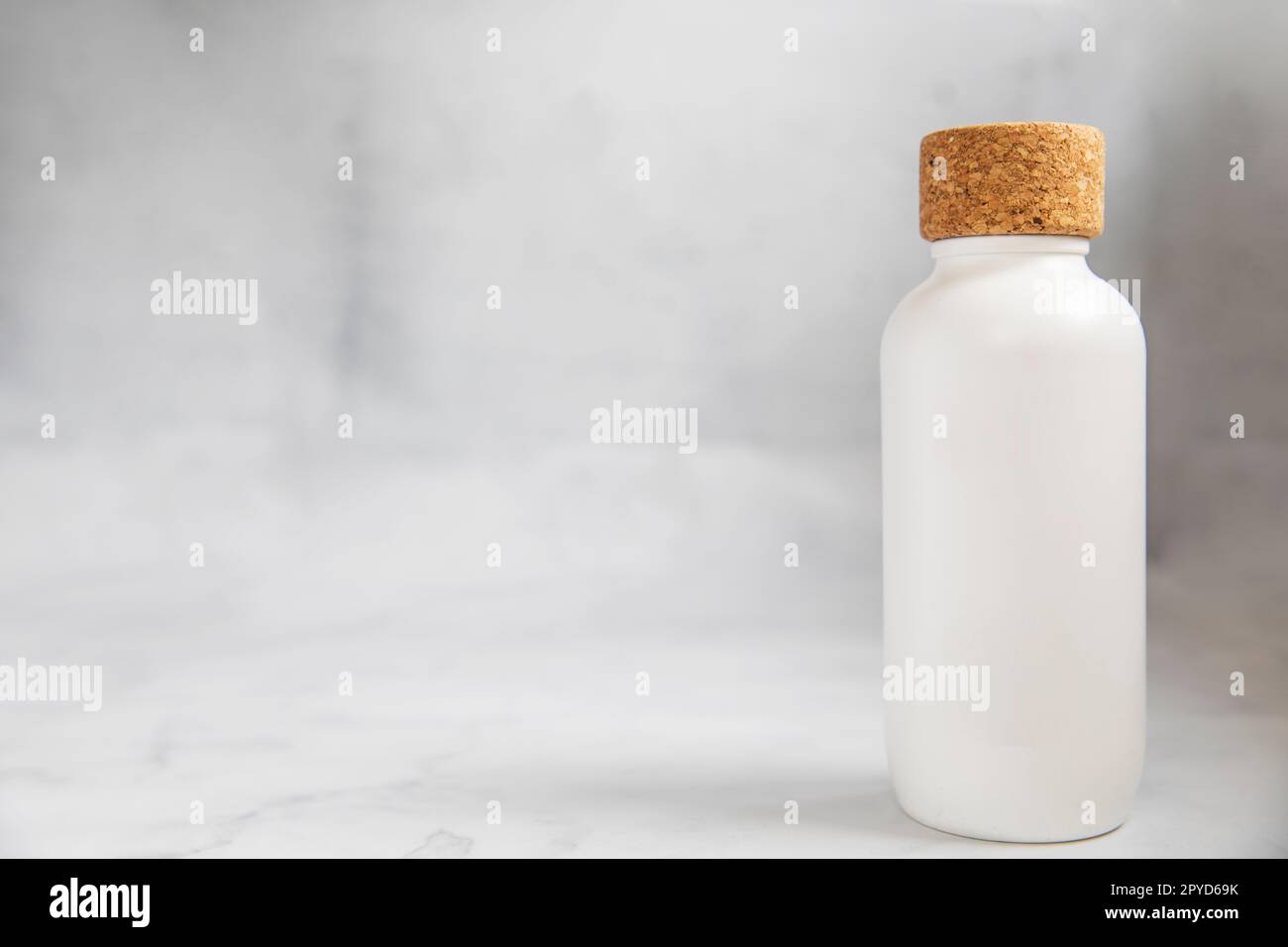 Bottiglia d'acqua ecosostenibile senza plastica, senza sprechi, stile di vita sostenibile. Scelta di articoli privi di plastica alternativi a quelli monouso. Bottiglia in plastica e bottiglia in vetro sgualcita su sfondo blu pastello. copia spazio Foto Stock