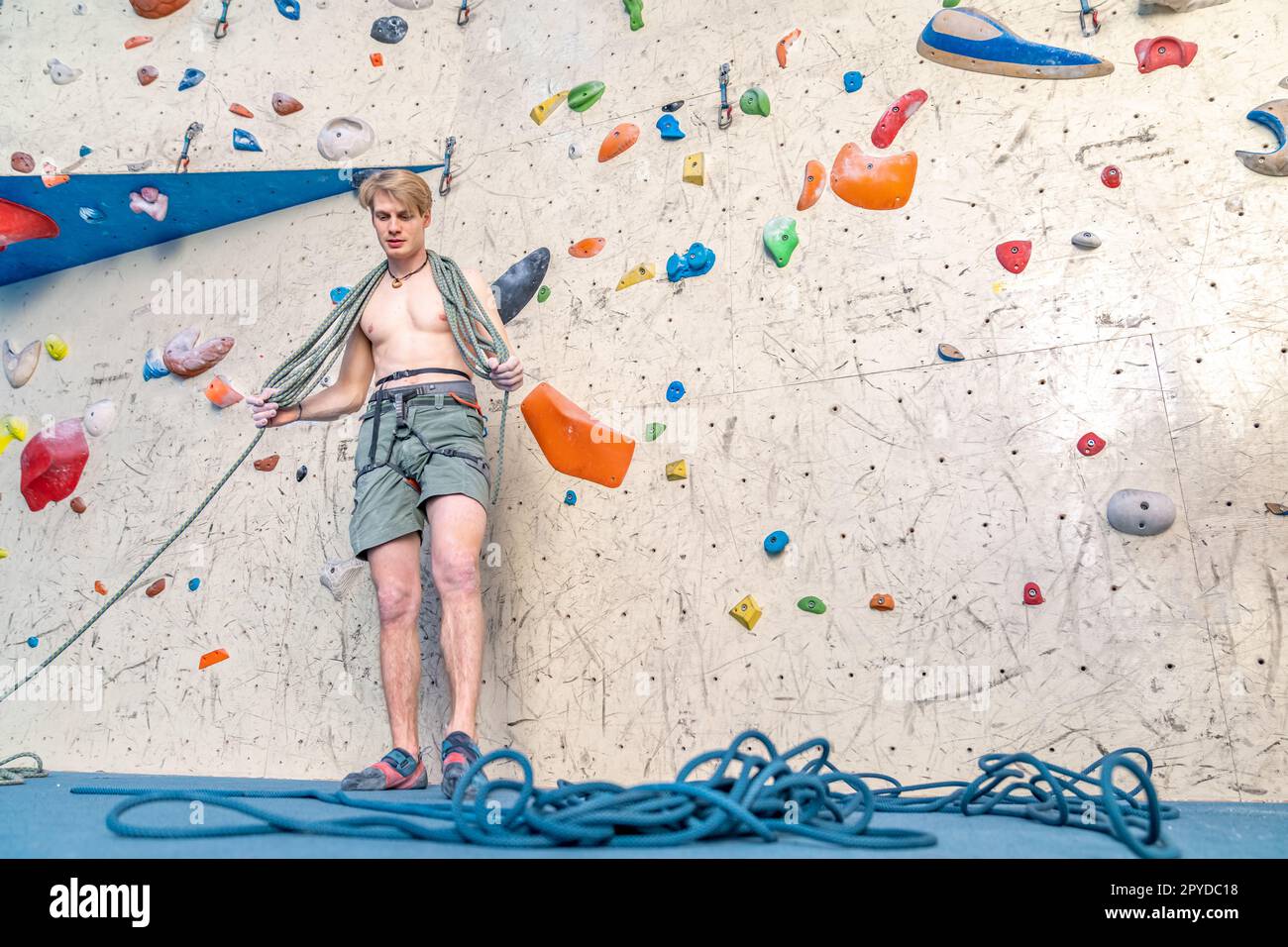 avvolgimento di una corda da arrampicata da parte di un giovane arrampicatore Foto Stock
