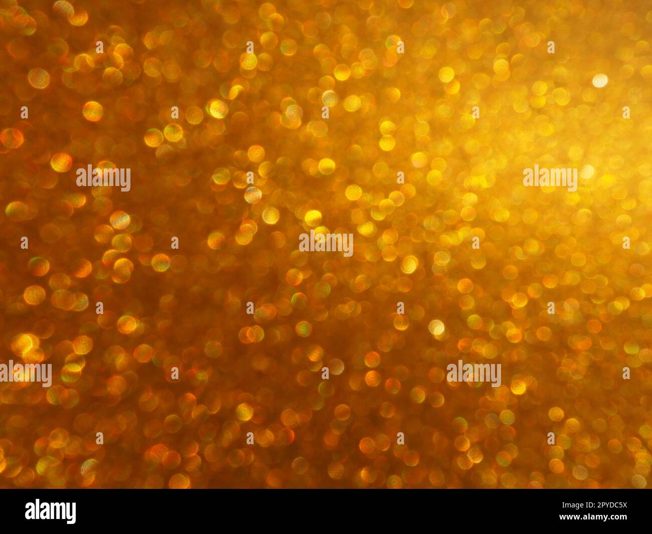 Luce bokeh di brillantezza dorata. Sfondo dorato con texture glitter. Carta da imballaggio glitter brillante con paillettes e scintillanti. Bokeh dorato e glitter festivi. Splendido sfondo. Foto Stock